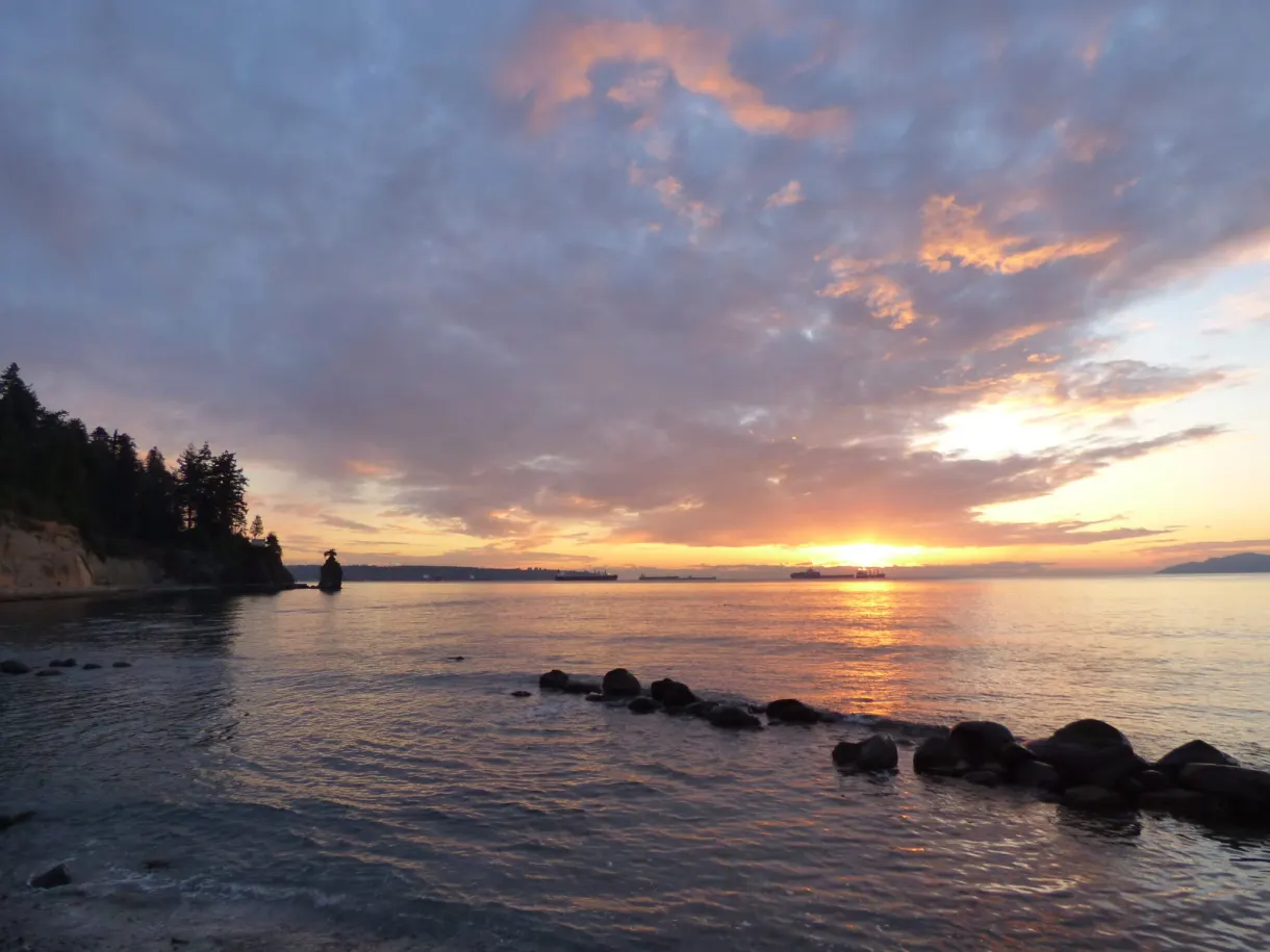 Sun setting over the bay dotted with rocks