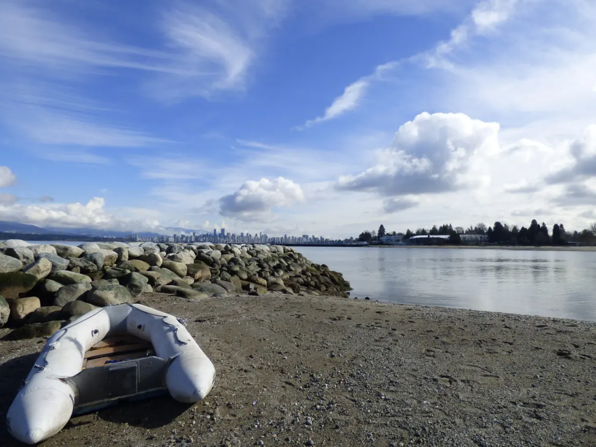 Inflatable dinghy pulled up onto the pebbles of the shore