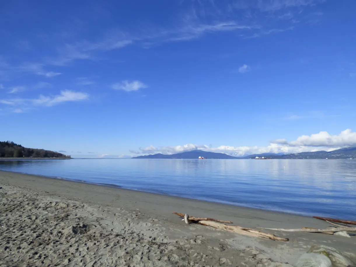 Brown sand and blue sea all the way to the mountains