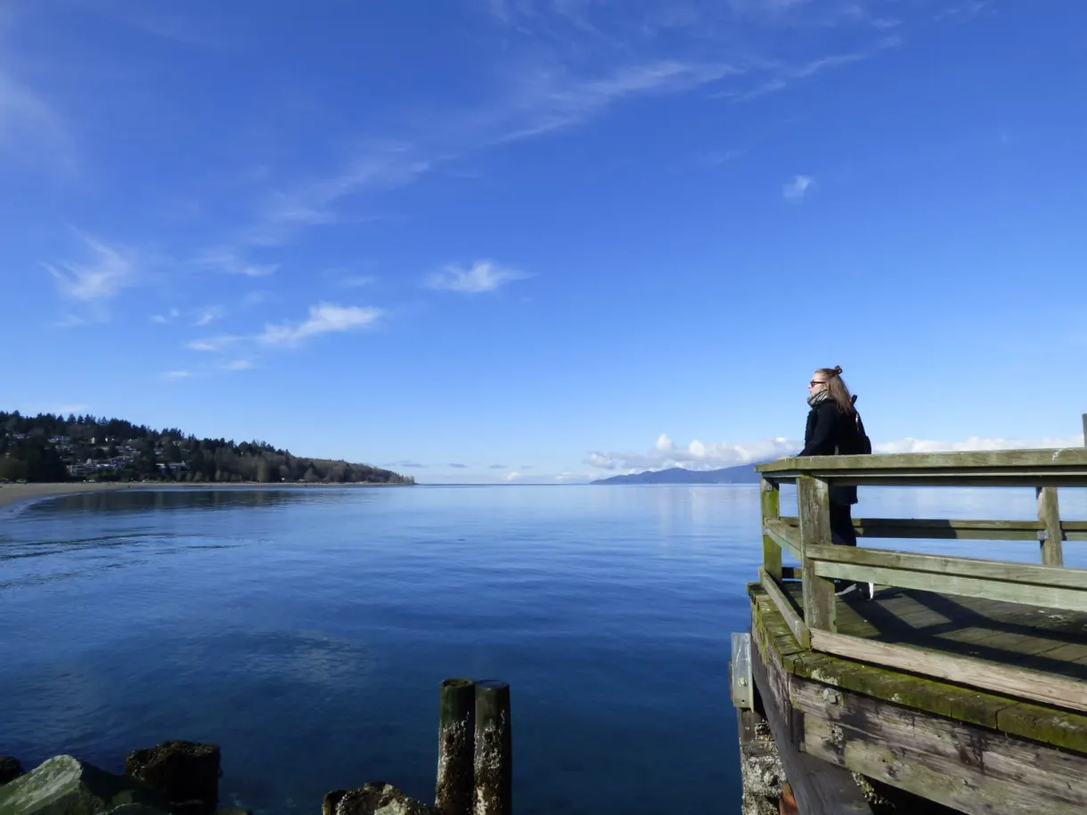 Young woman leaning over the railing of a wooden platform