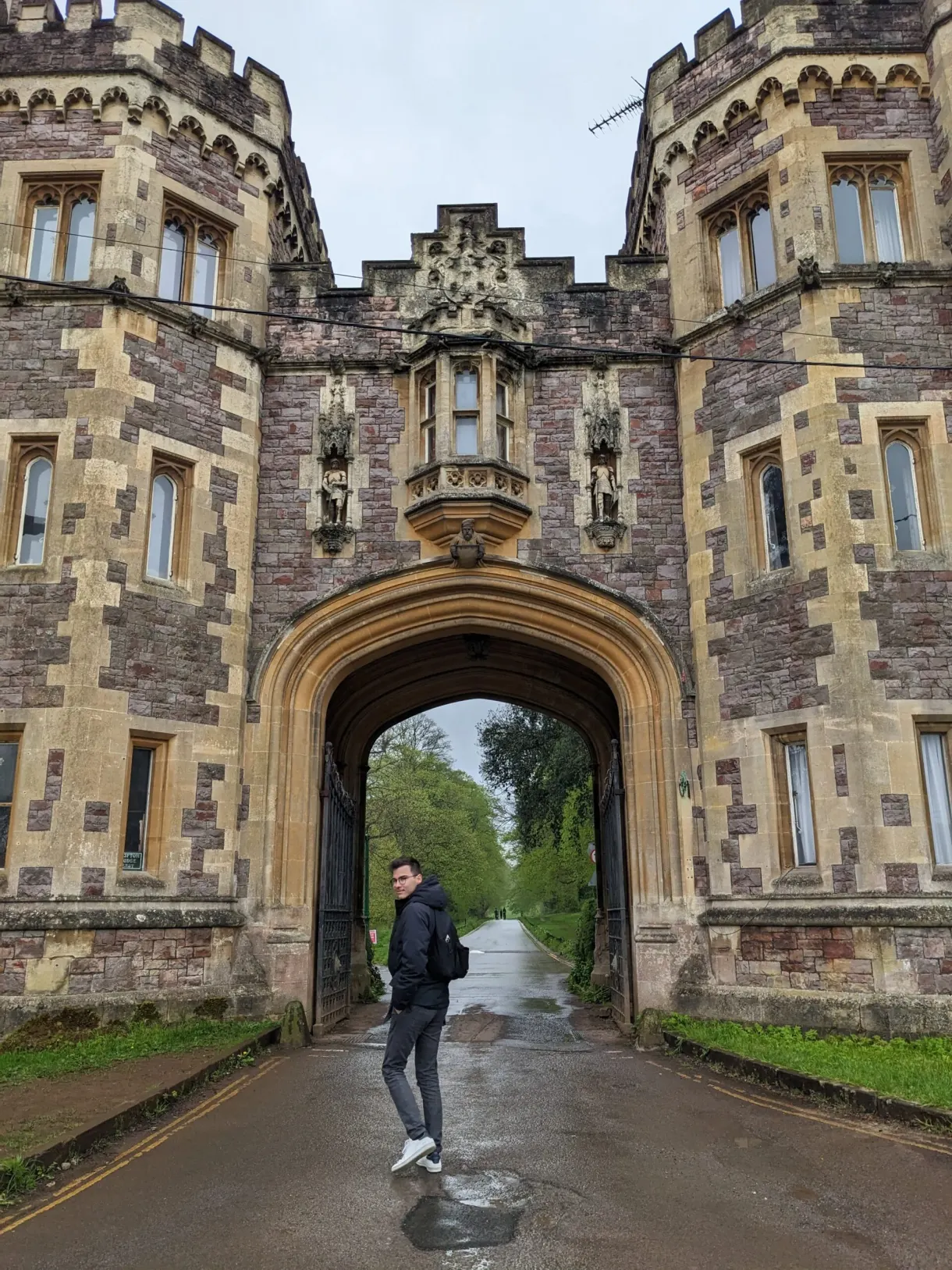 Vaulted passage of a neo-Gothic manor, figure beneath it