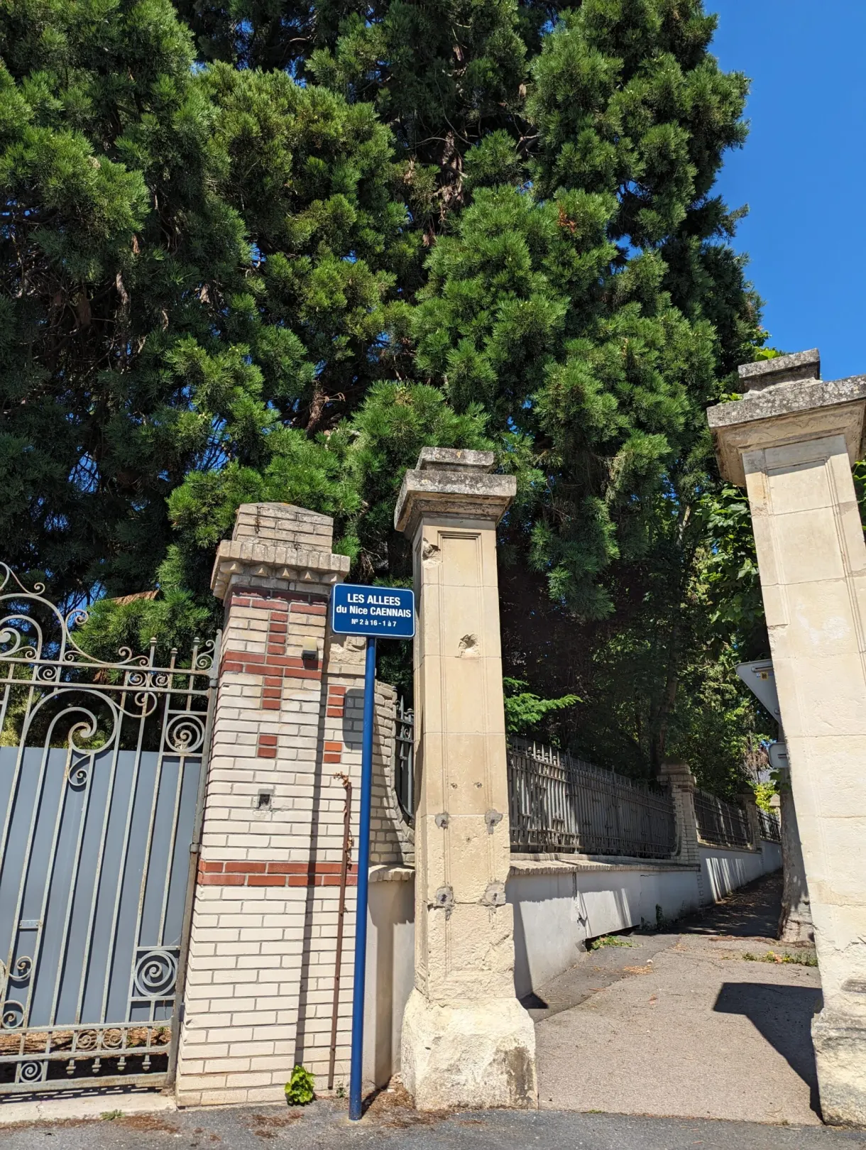 Blue iron gate between two brick and stone pillars
