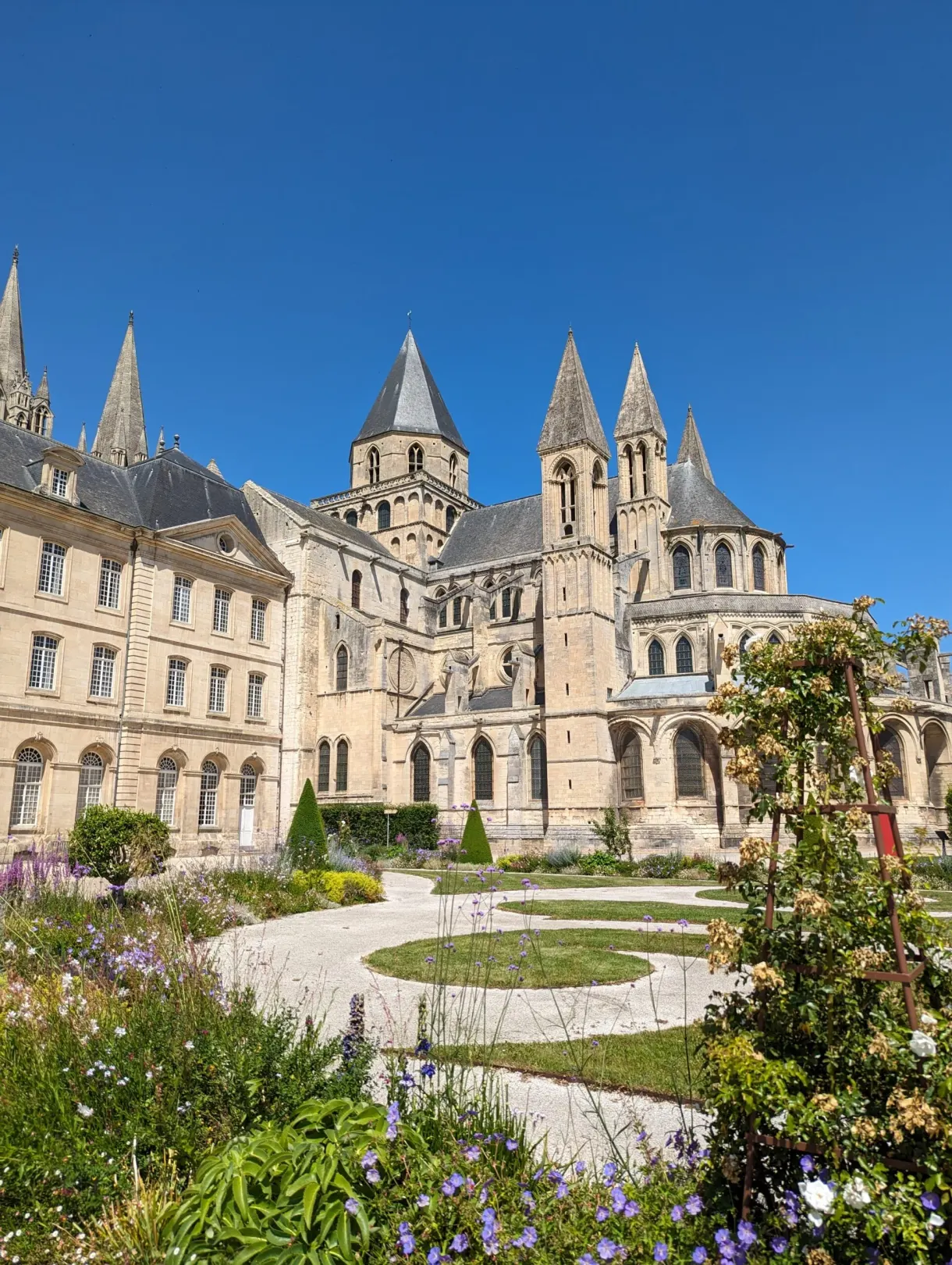 Chevet of the abbey church rising above the flower beds