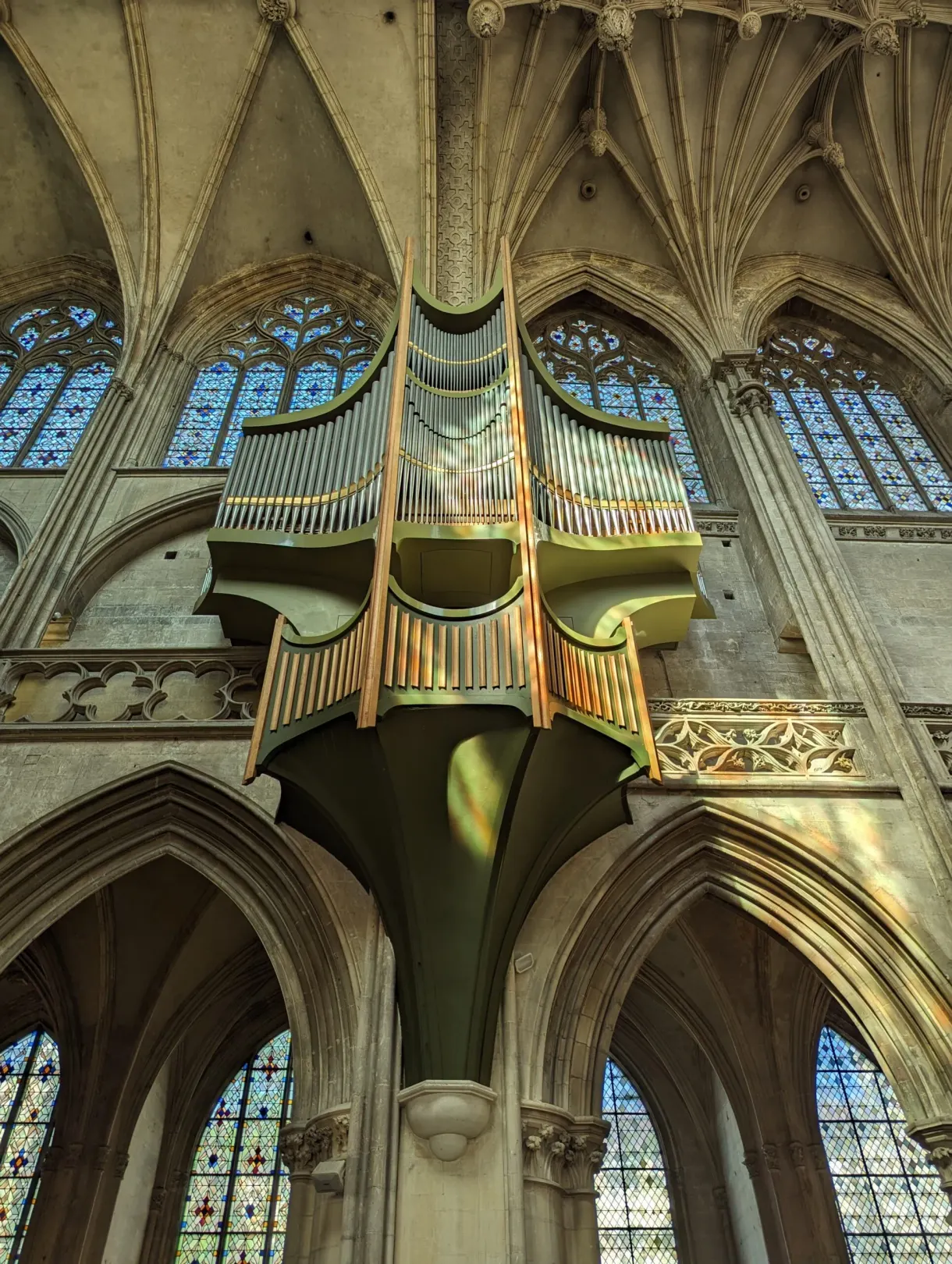 Gilded organ case beneath the vaults and the stained glass