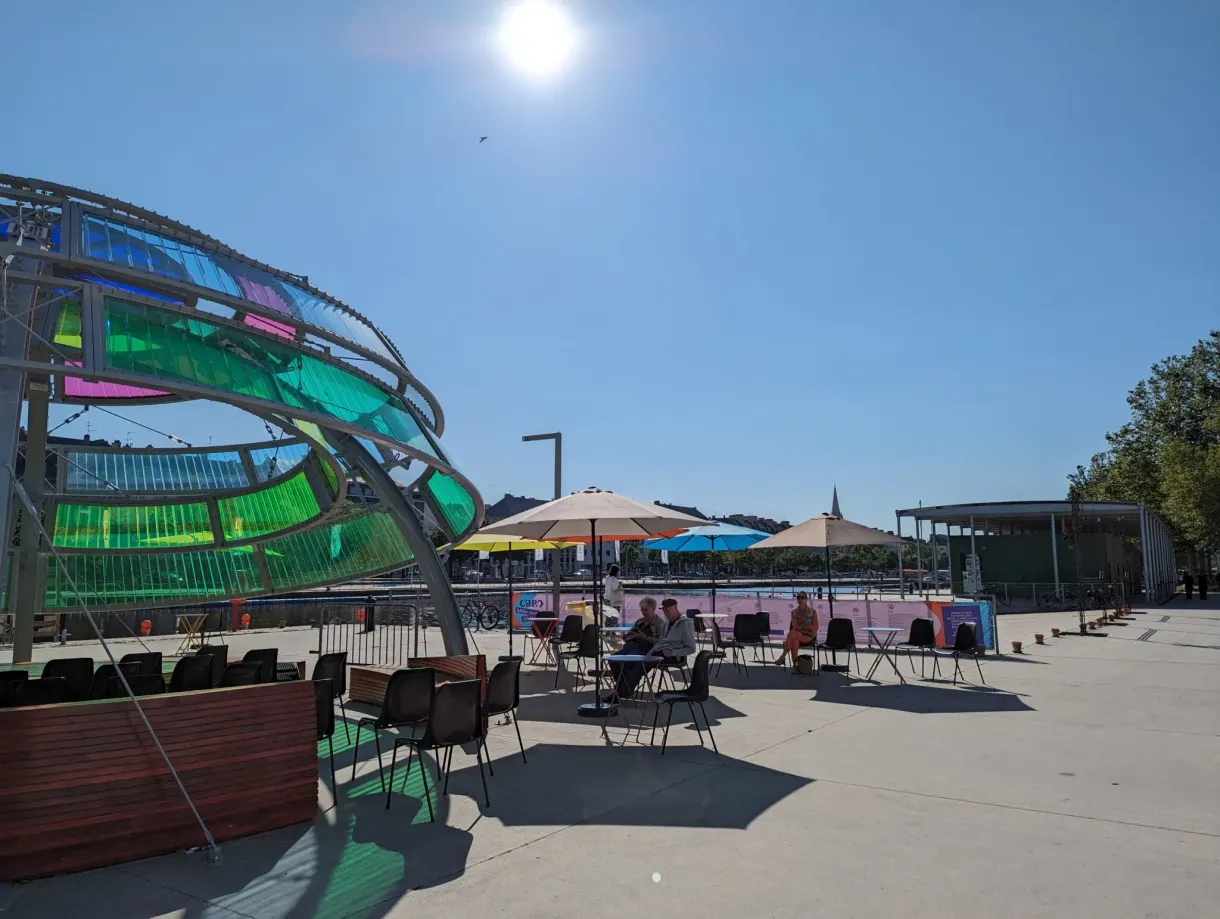 Summer terrace with colourful parasols under a green glass structure
