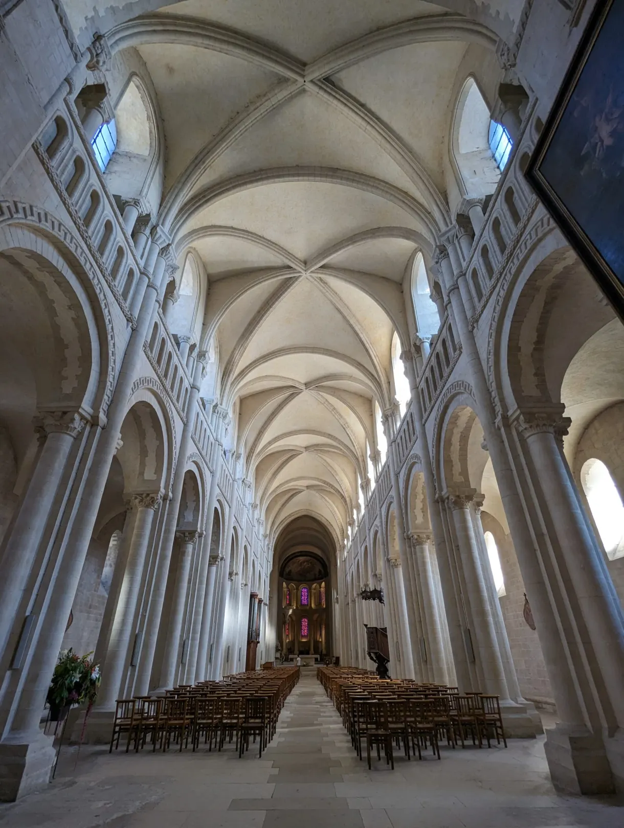 White vaulted nave with its chairs lined up towards the choir