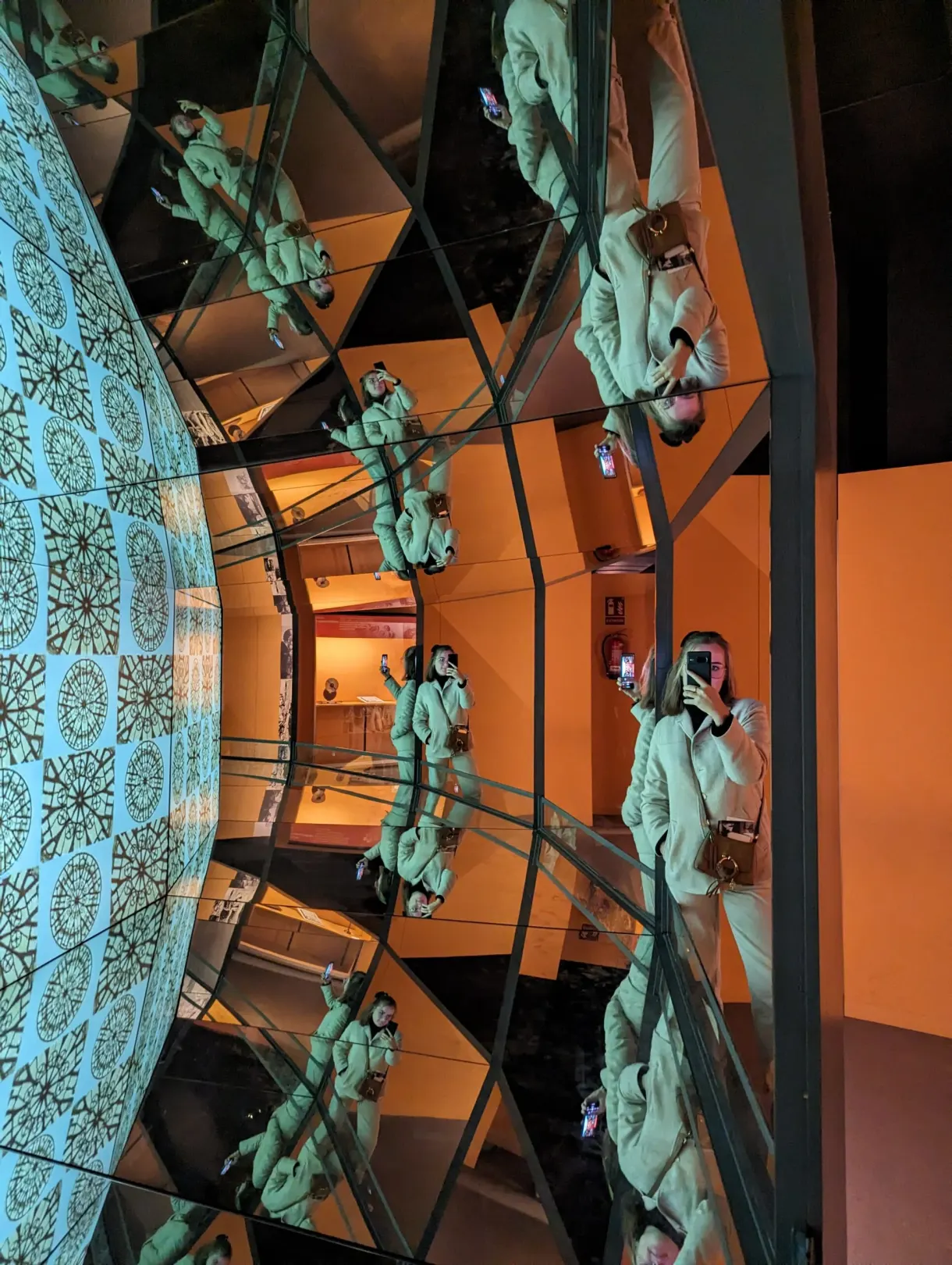 Play of mirrors multiplying the reflection of a visitor in green