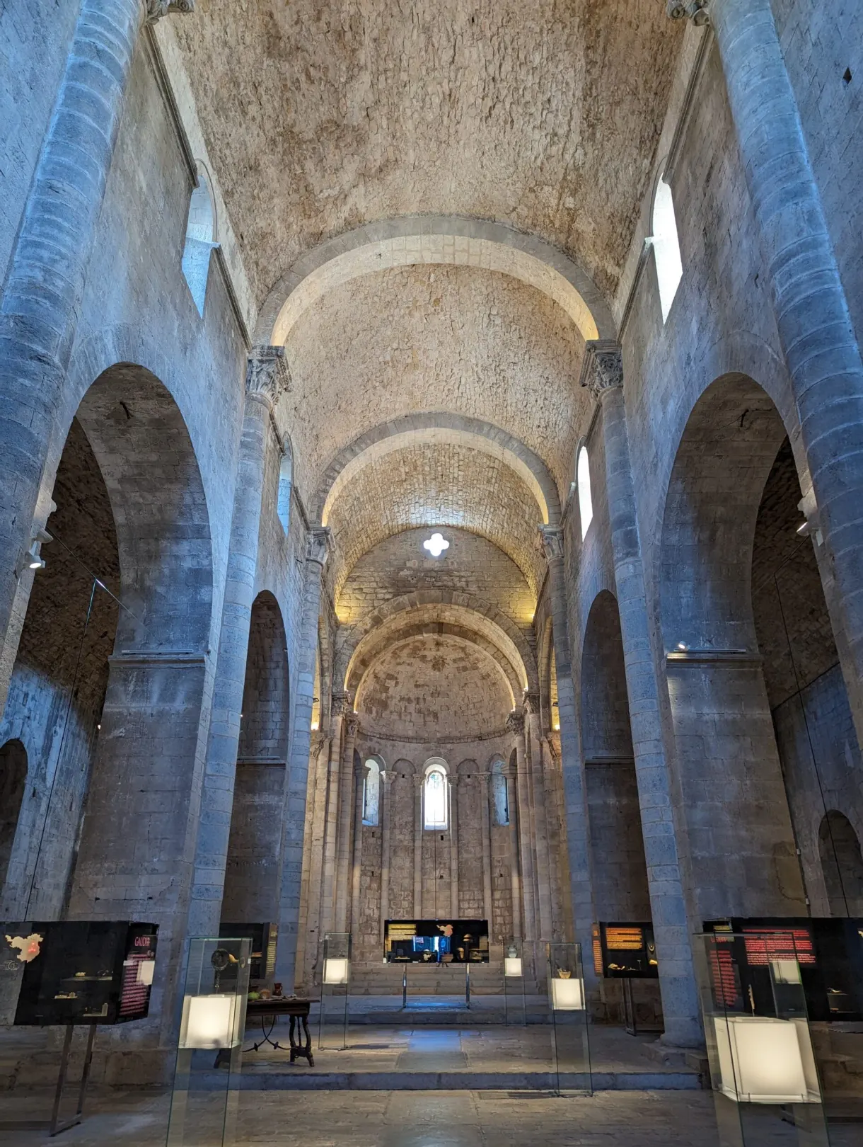 Romanesque nave turned into an exhibition room, display cases between the pillars