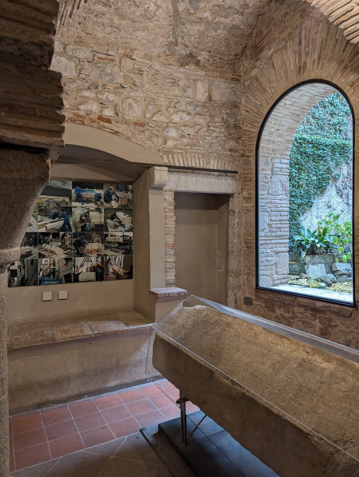 Stone sarcophagus in a vaulted room opening onto a patio
