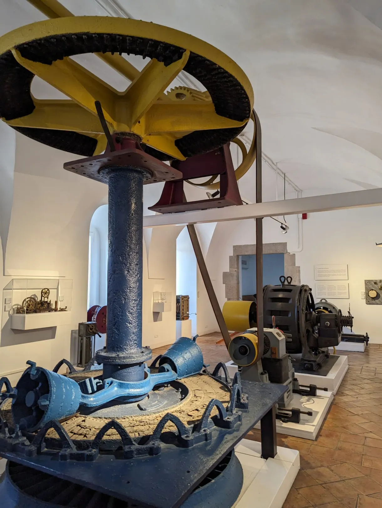 Old industrial machines on display, large yellow wheel in the foreground