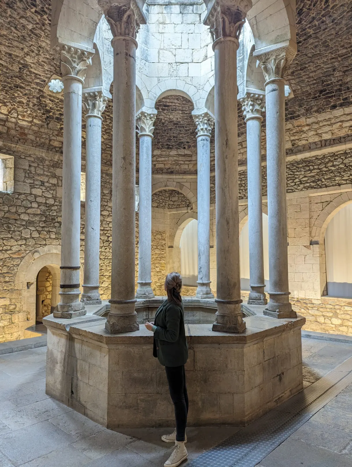 Visitor looking at the central basin ringed with pale columns