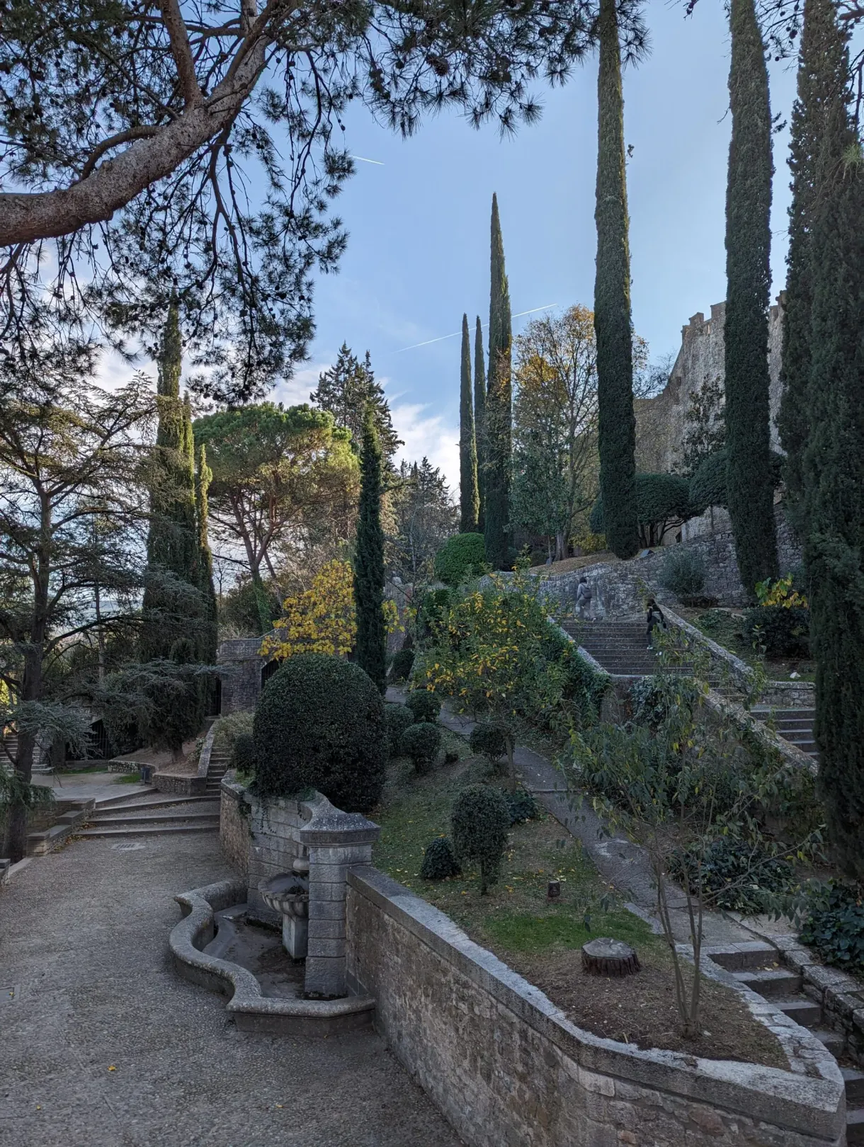 Terraced gardens planted with cypresses at the foot of the ramparts