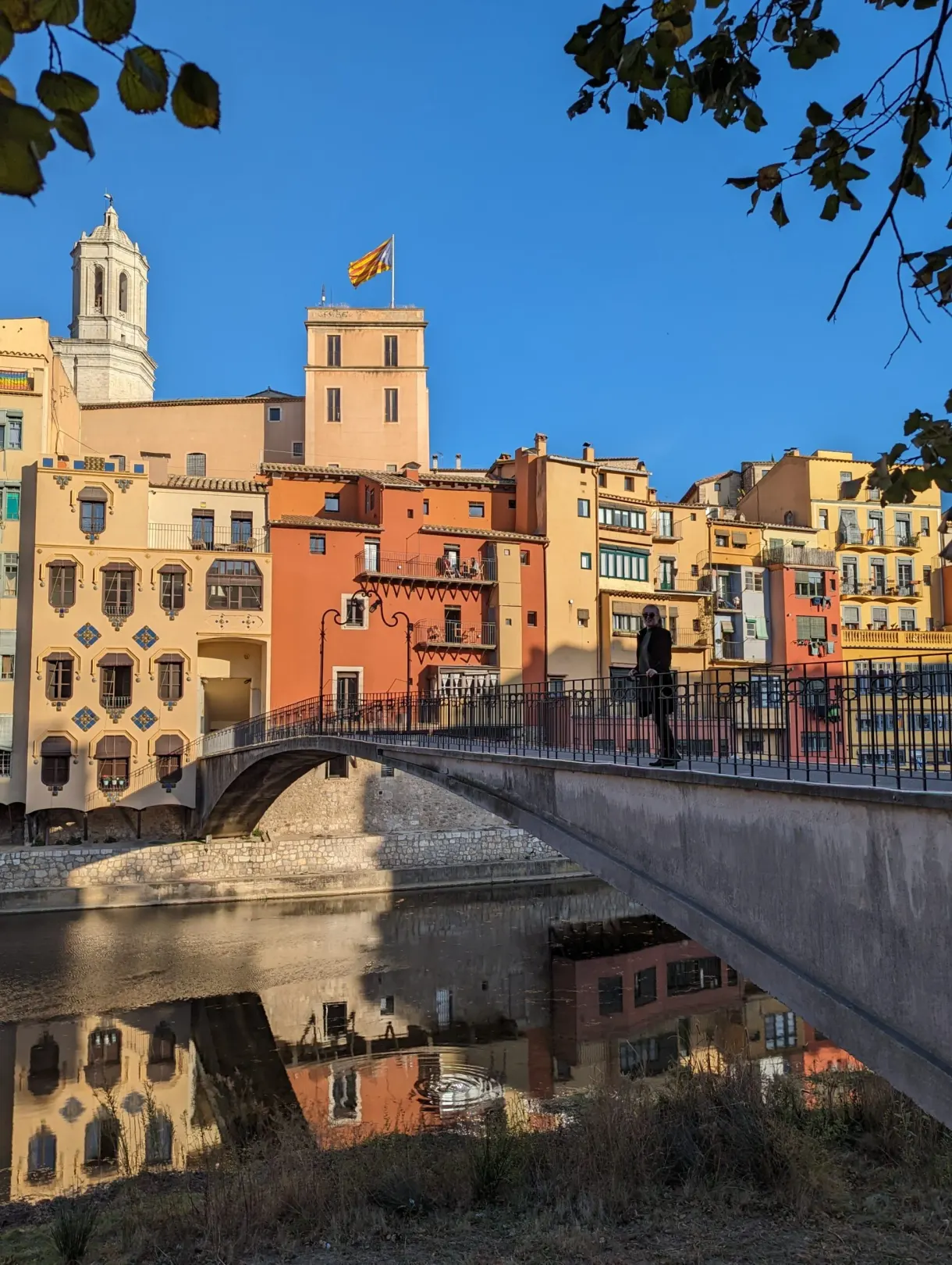Stone bridge and ochre facades topped by a Catalan flag