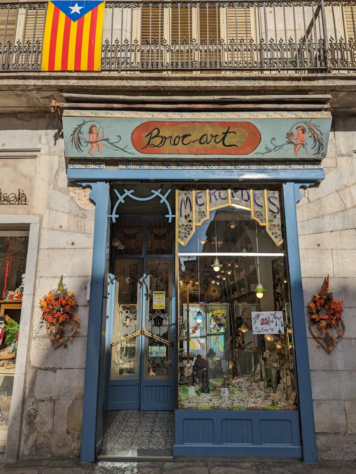 Blue front of an antiques shop beneath a Catalan flag