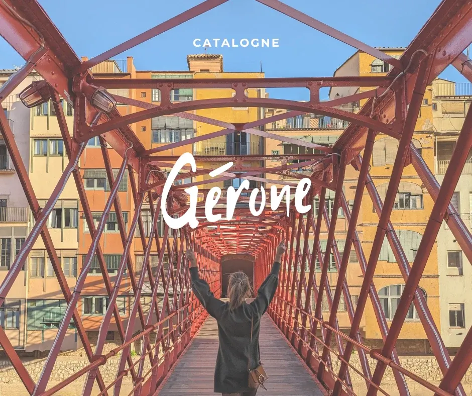 Traveller with arms raised on the red footbridge with the yellow facades