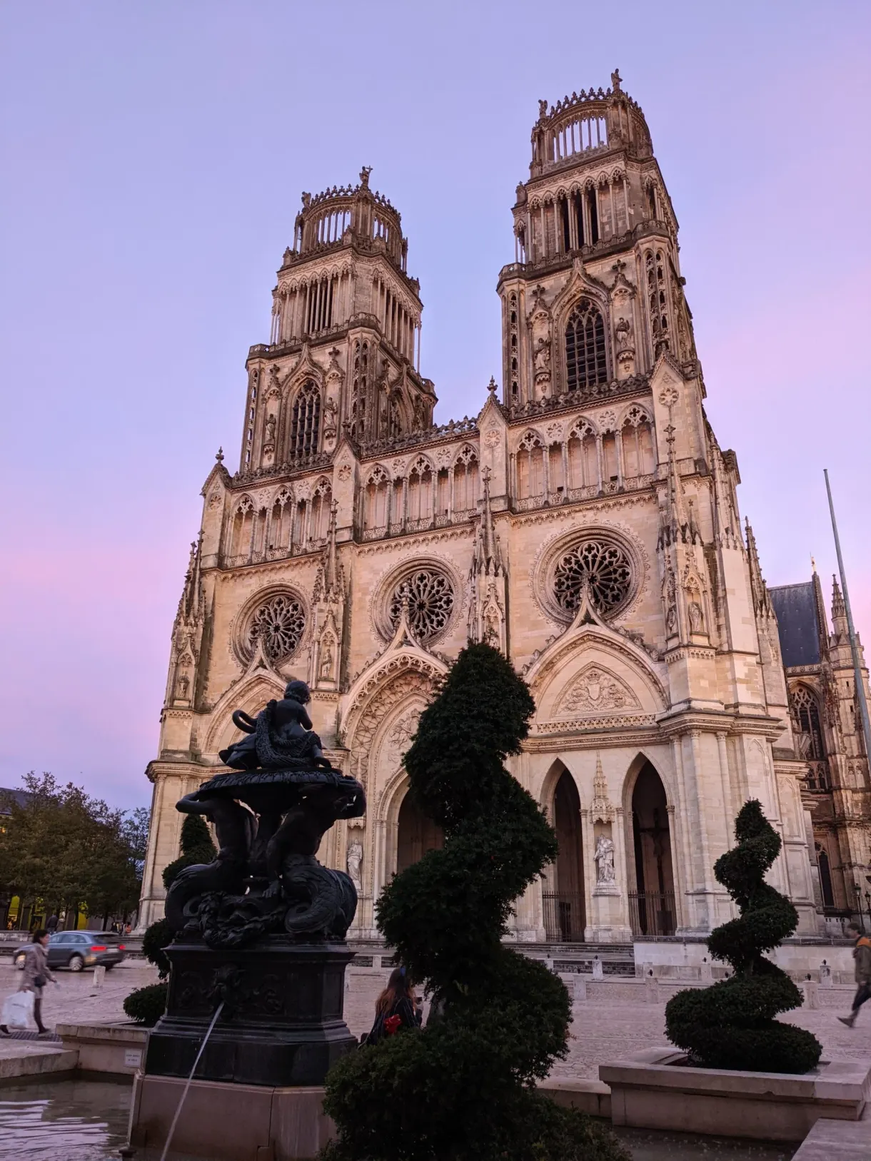 Pink sky behind the towers and the clipped yews