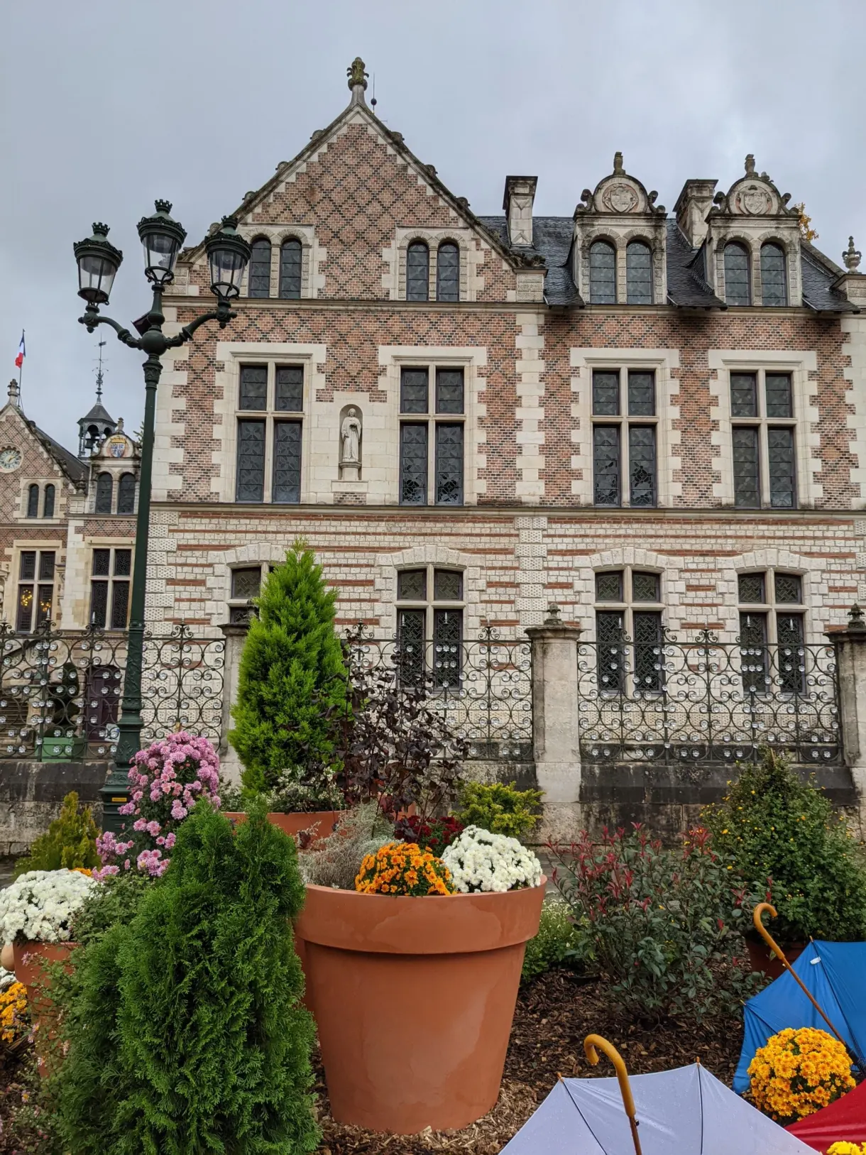 Autumn beds at the foot of a pink brick facade