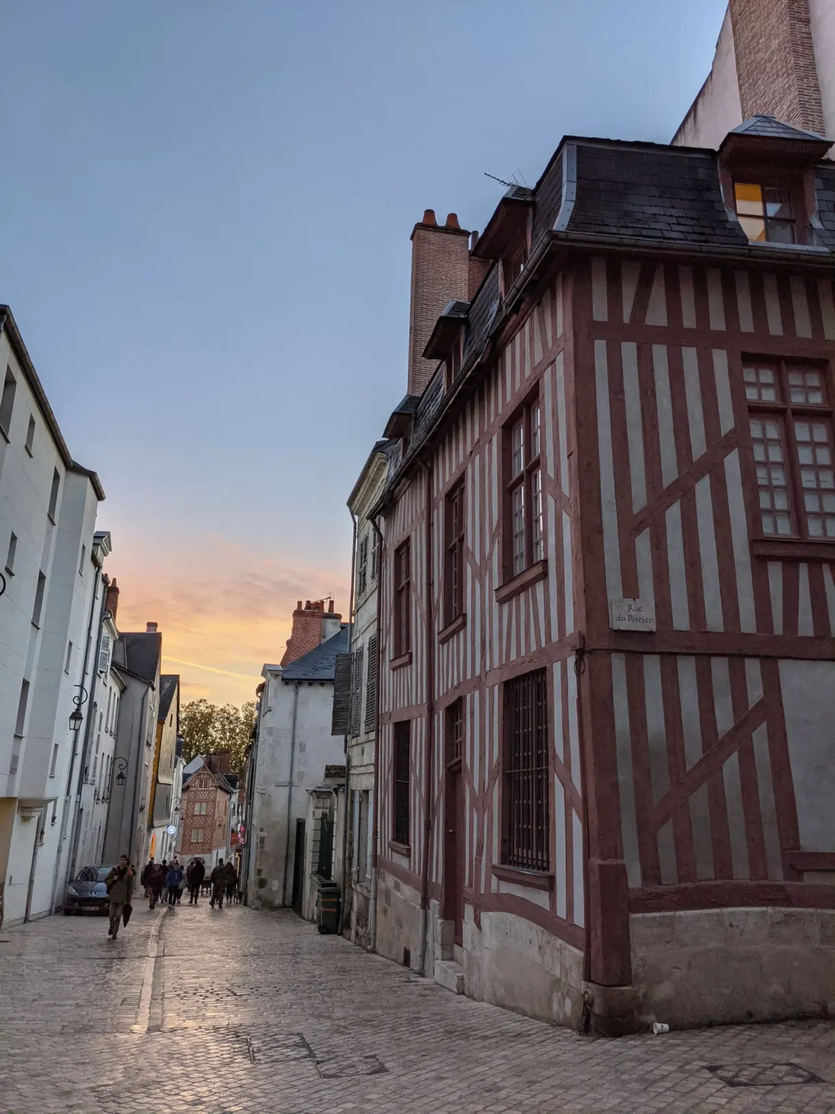 House with red half-timbering on a street corner at dusk