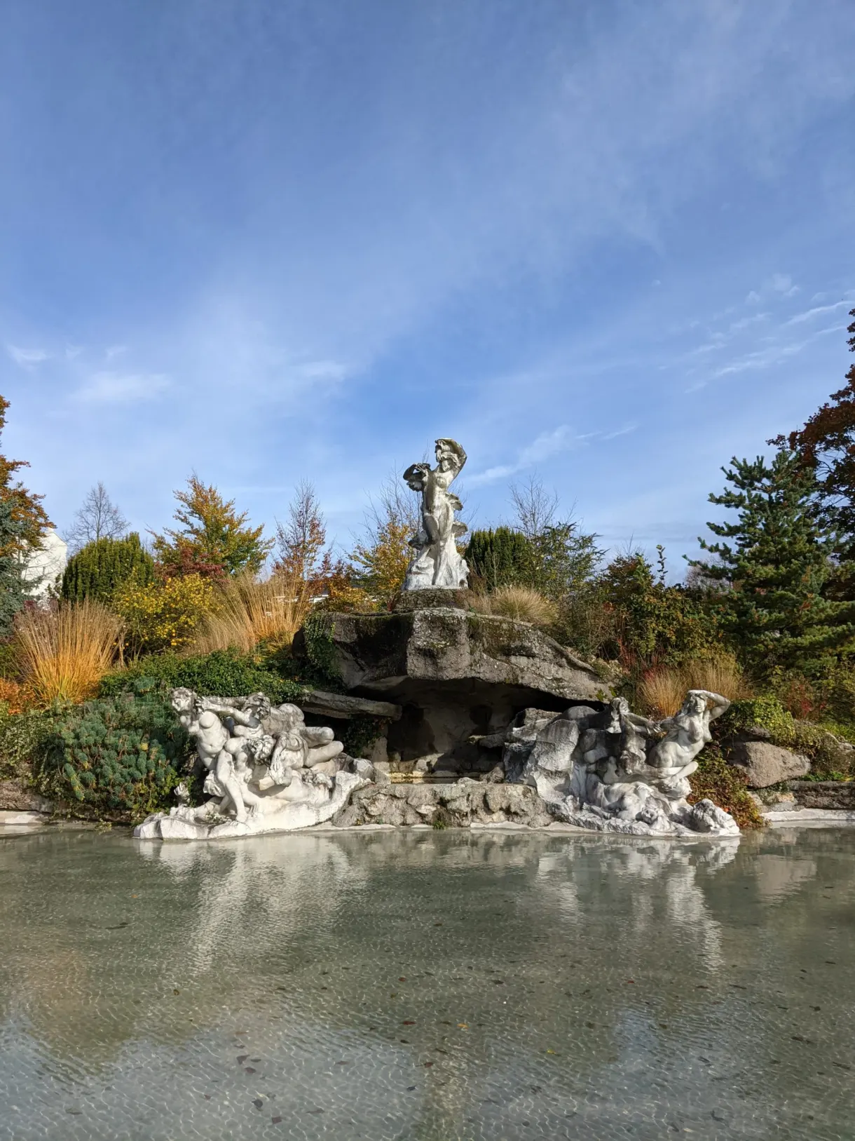 Rockery and statue above a pond in the park