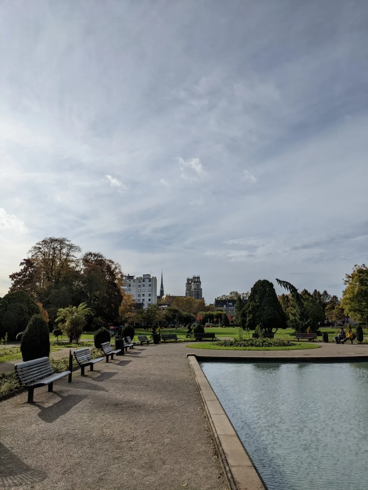 Rectangular pond lined with benches and flower beds