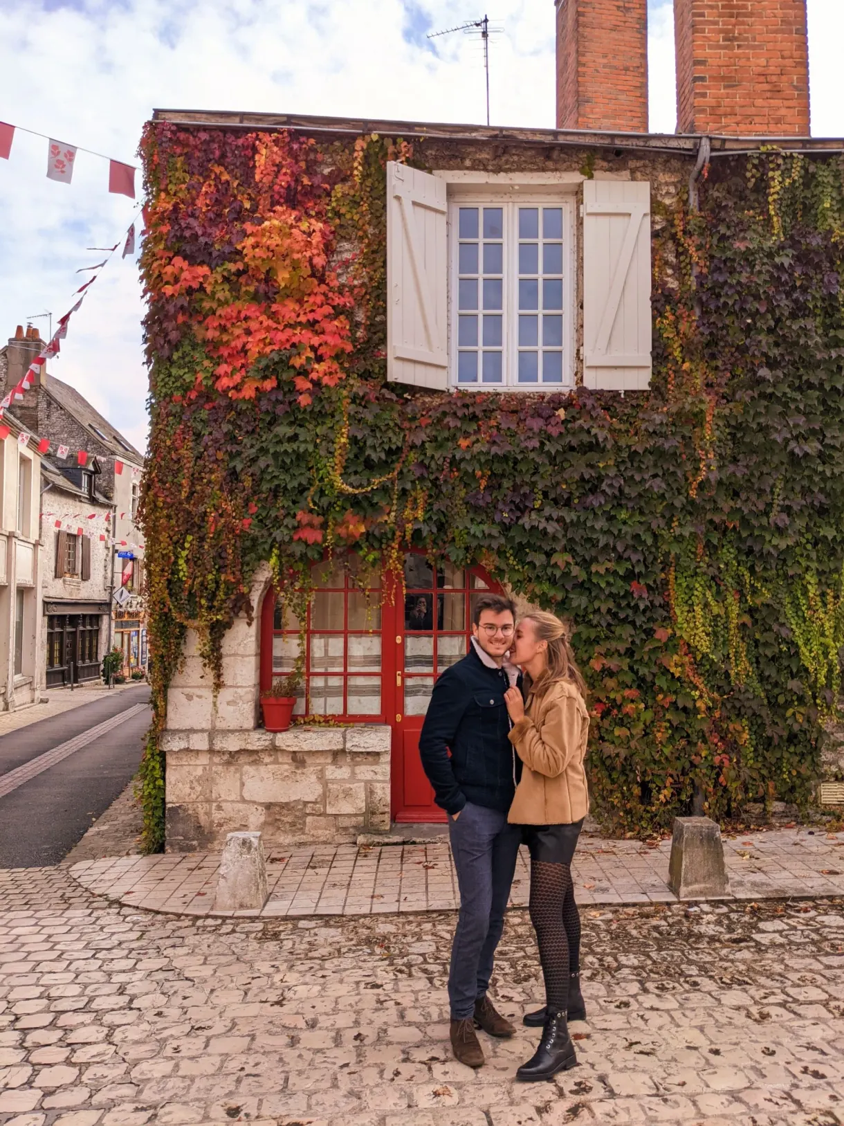 Couple in front of a house covered with red Virginia creeper