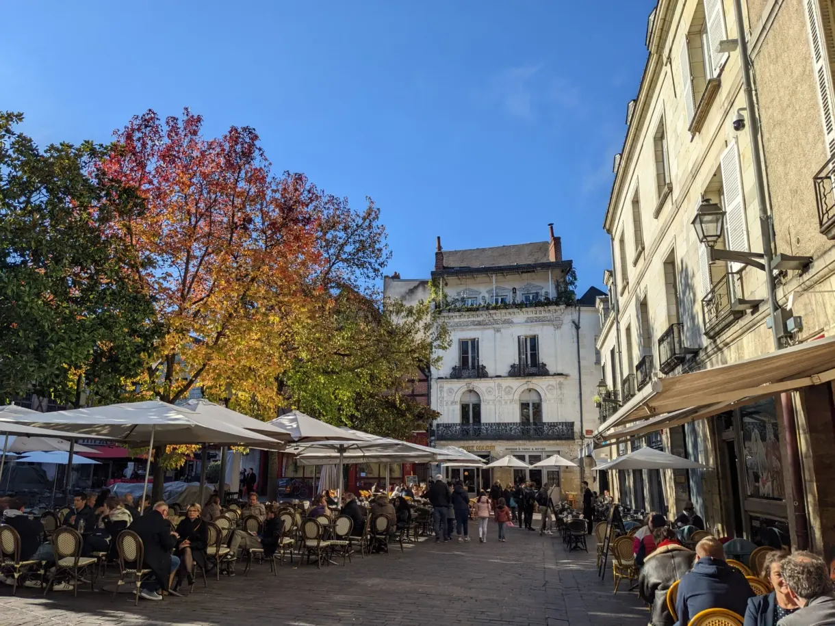 Packed cafe terraces on a square in the old town of Tours in autumn