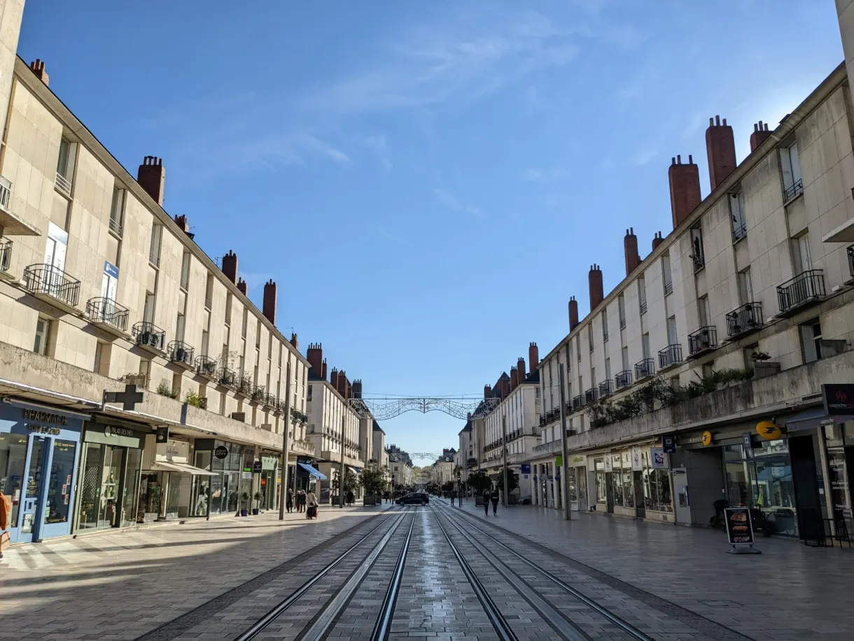 Straight shopping street crossed by the tram tracks