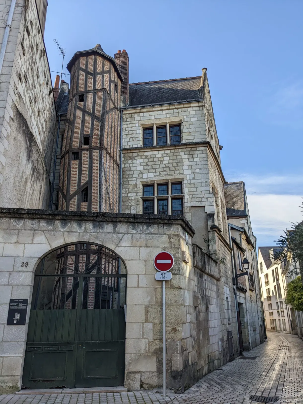 Sloping lane between a half-timbered house and a stone wall