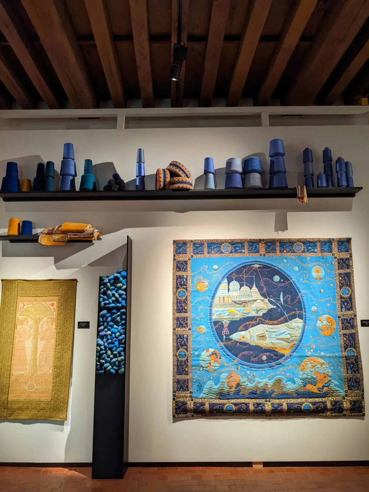 Blue vases lined up above a round marine tapestry