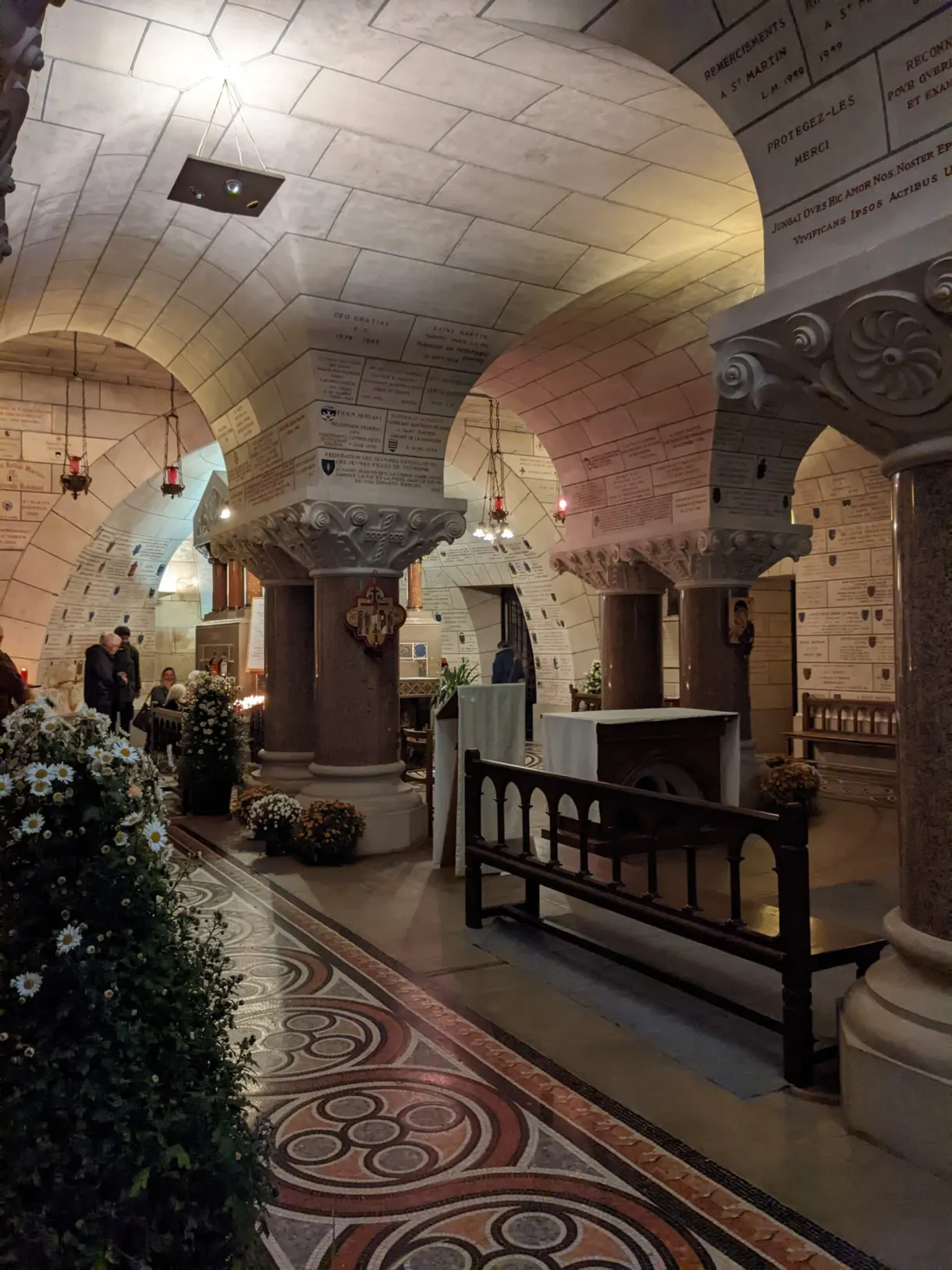 Vaulted crypt with a mosaic floor, decorated with white flowers