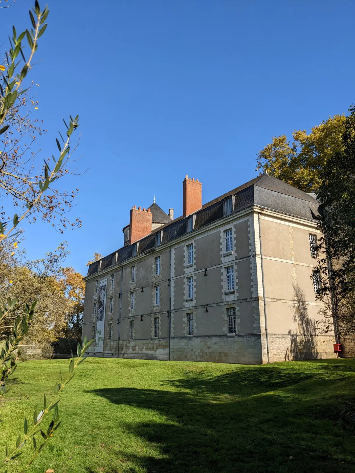 Long building with brick chimneys set on a lawn