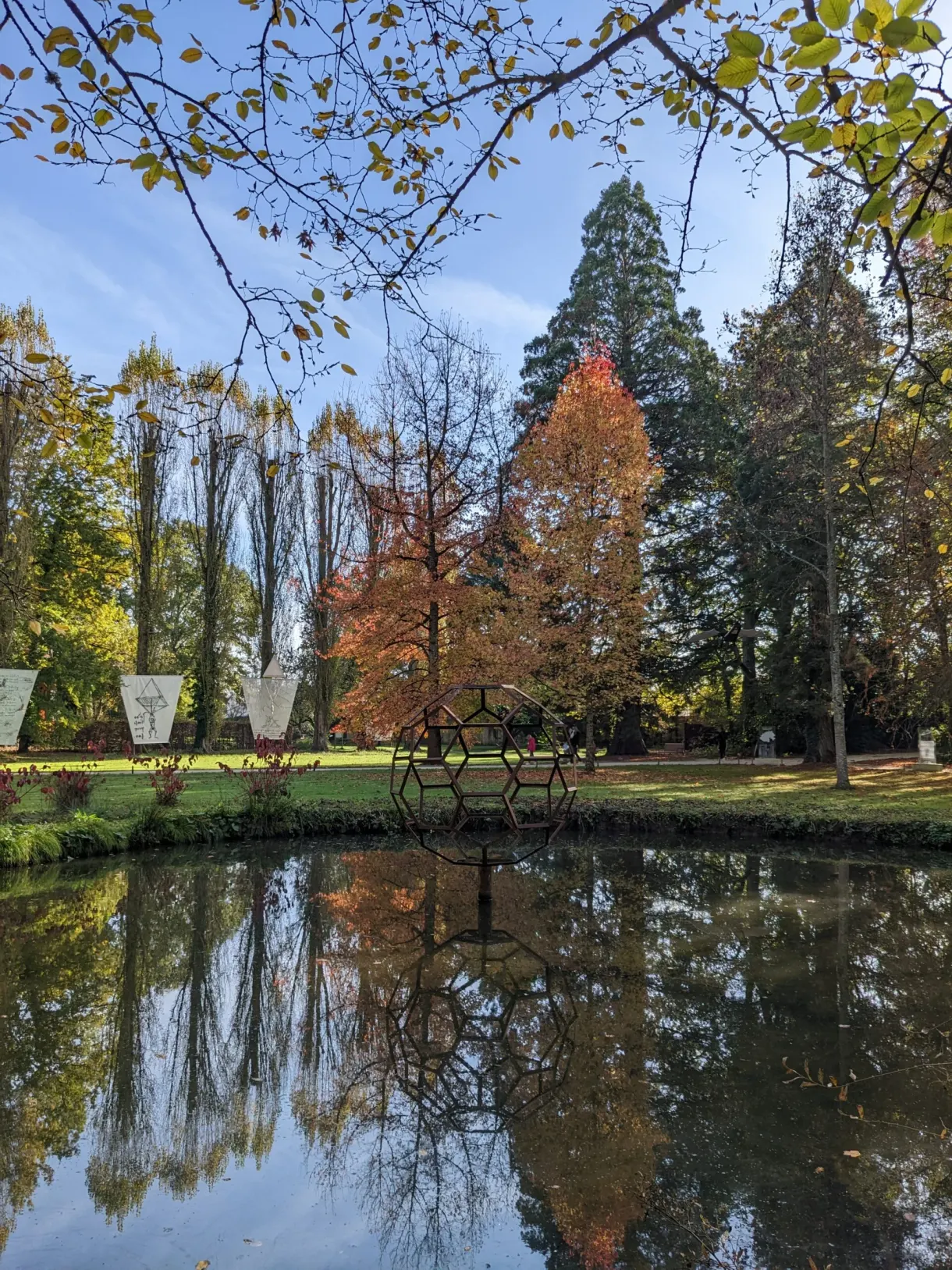 Pond reflecting the autumn trees and the sculptures of the park