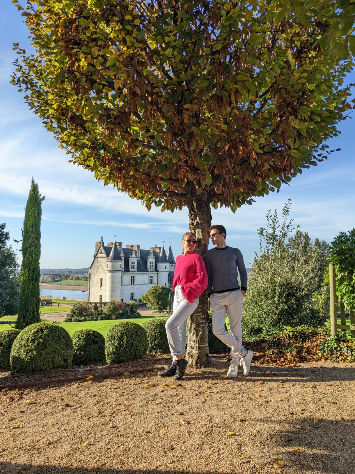 Couple leaning against a tree, château and Loire in the background