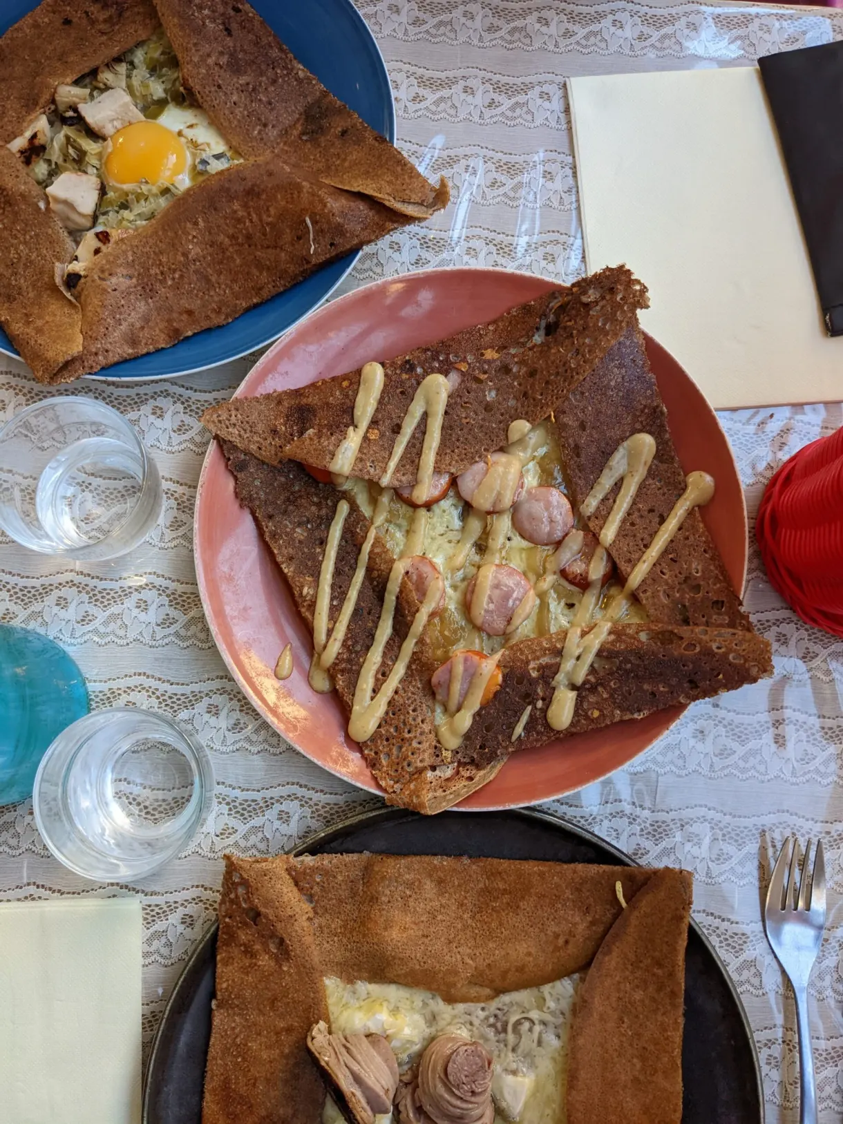 Crêperie table set with complete galettes and glasses