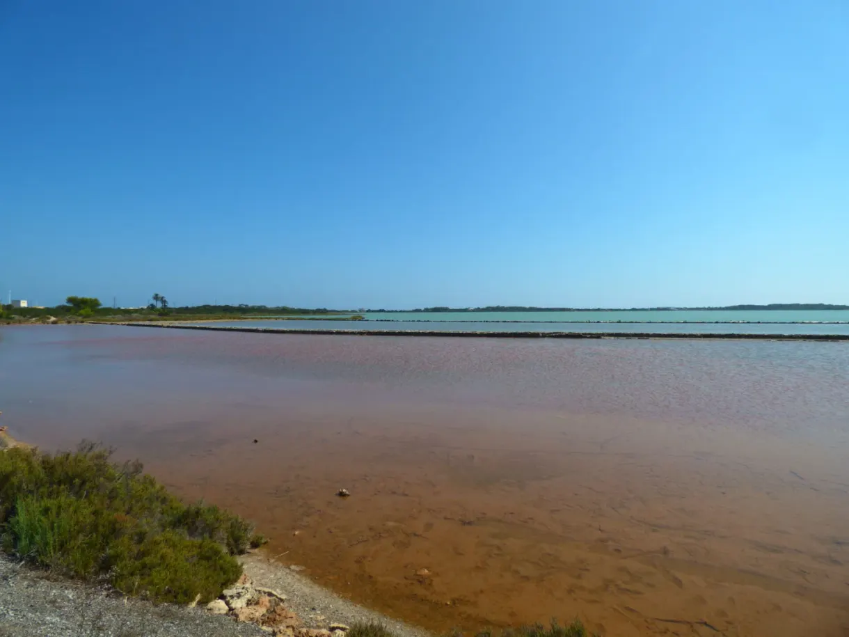 Brown lagoon of the salt pans closed off by a sand bar