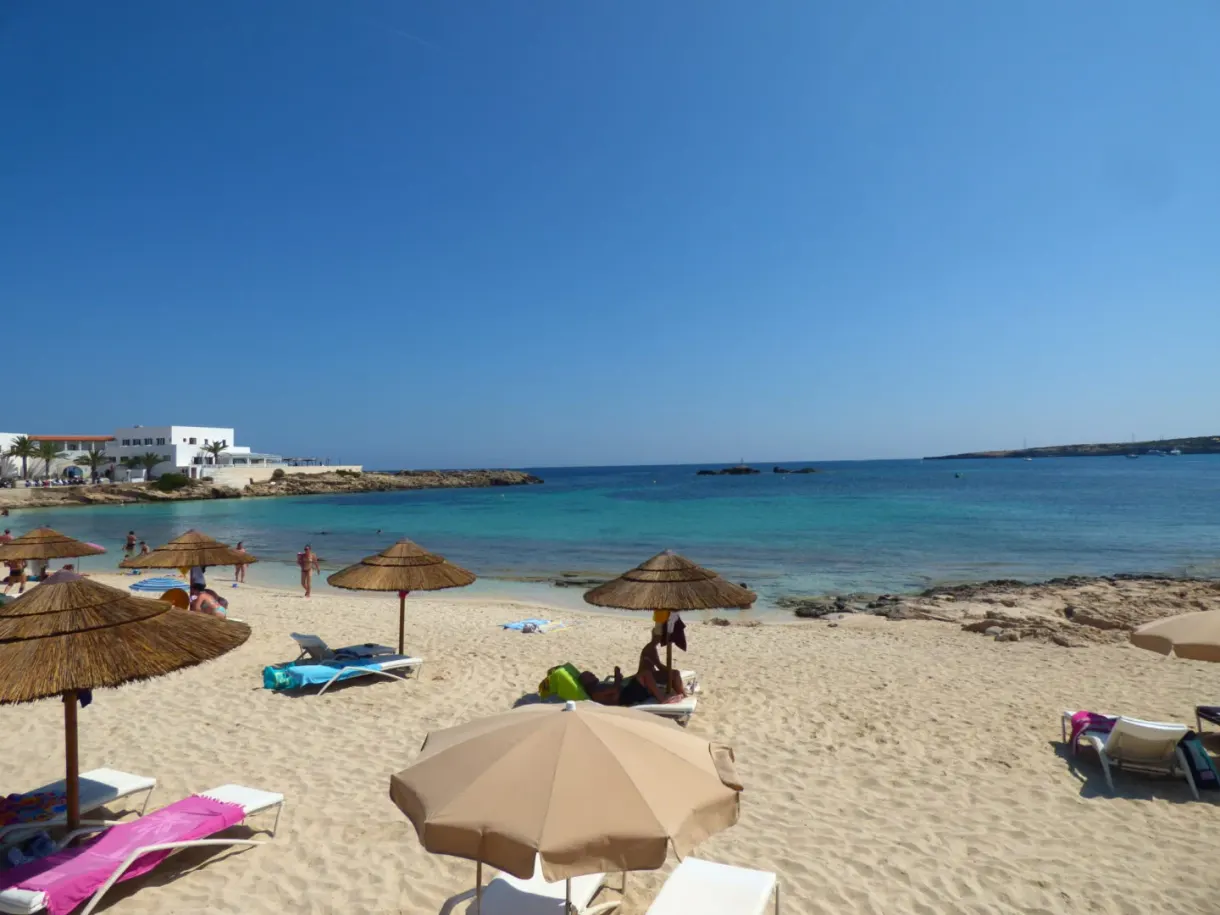 Straw parasols and sun loungers lined up on the beach
