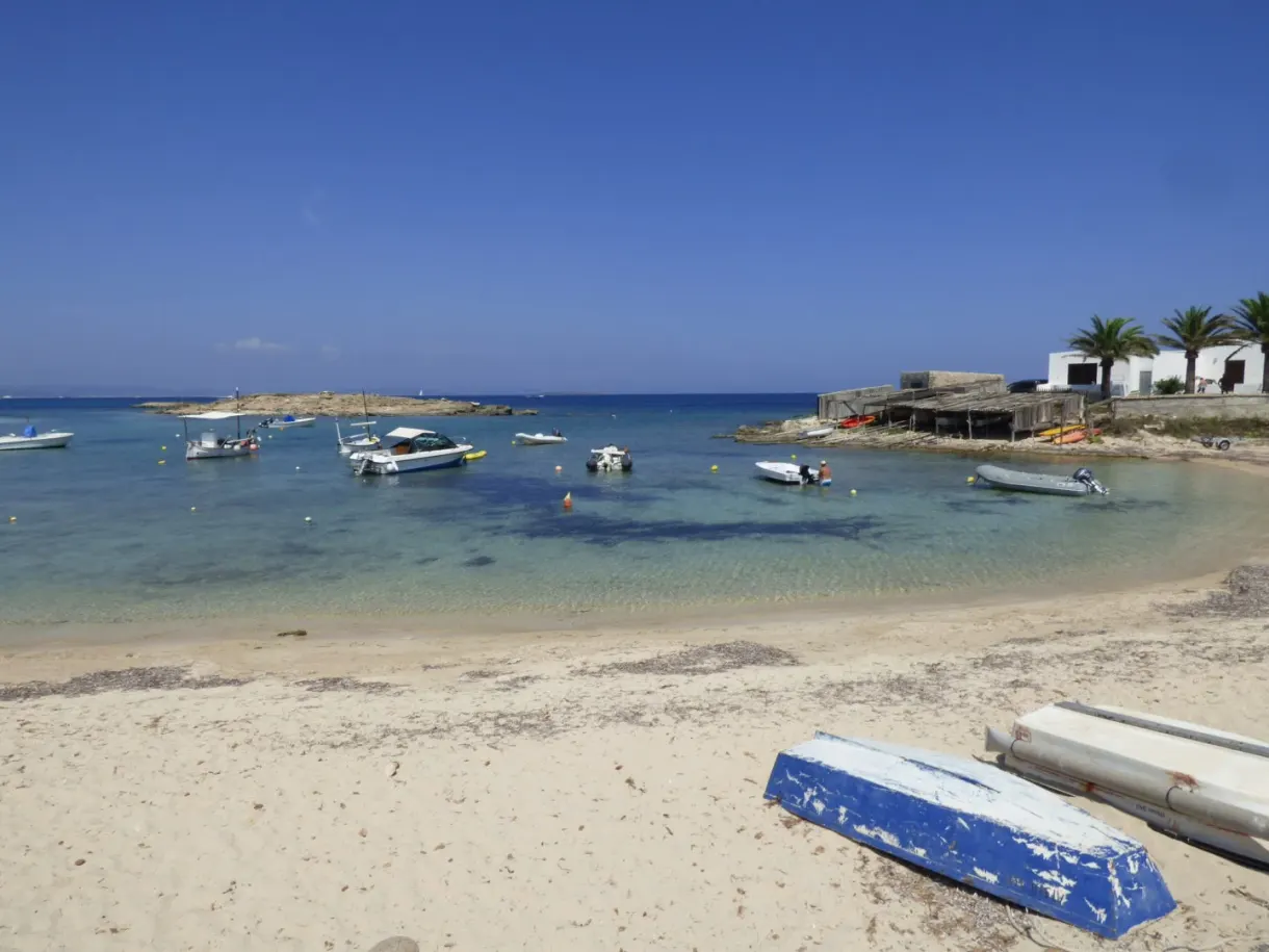 Boats beached on the sand in front of small huts