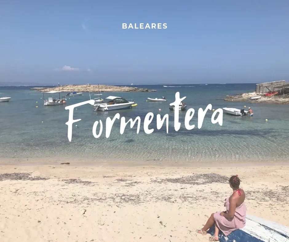 Sitting on the sand facing the boats at anchor