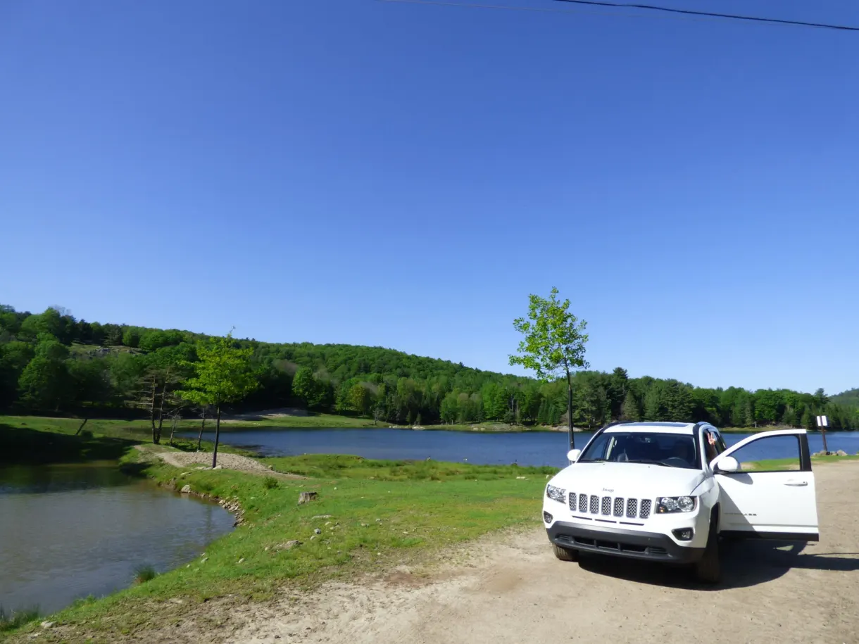 Voiture arrêtée sur la piste au bord d'un étang
