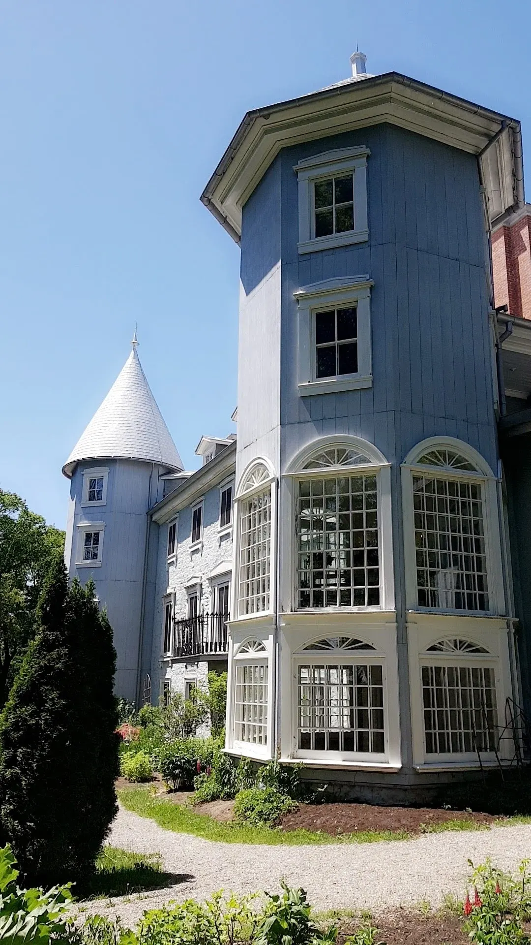 Maison bleue à tourelle et grandes baies vitrées