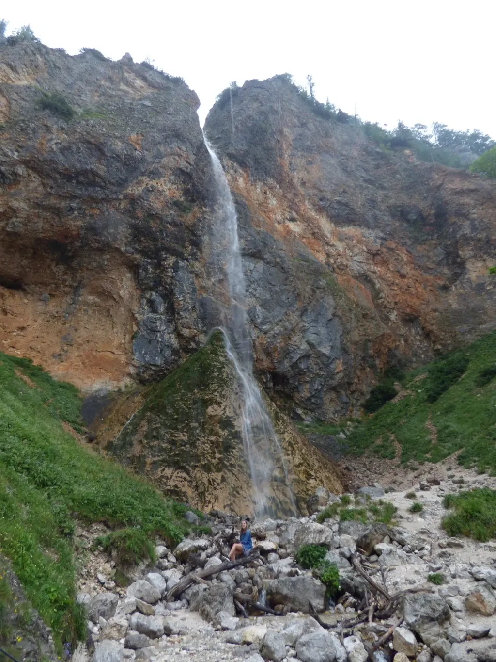 Waterfall dropping onto a scree of pale stones