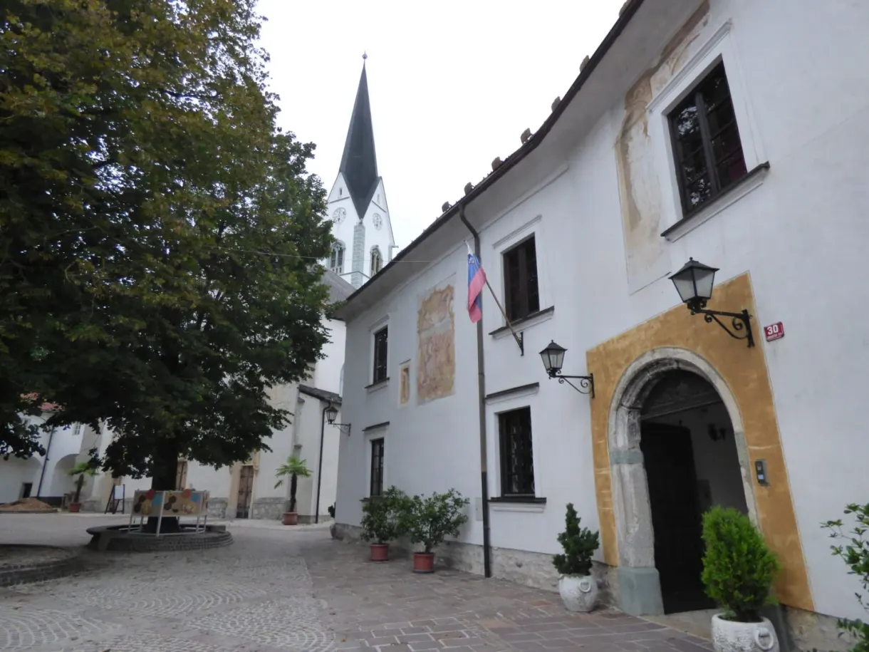 Cobbled square in front of a church and a yellow gateway