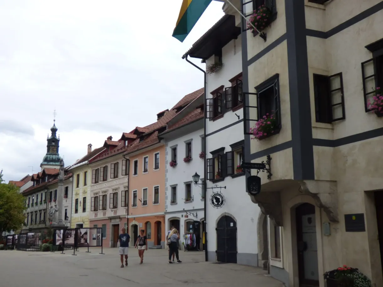 Sloping street, white houses and a bell tower at the far end