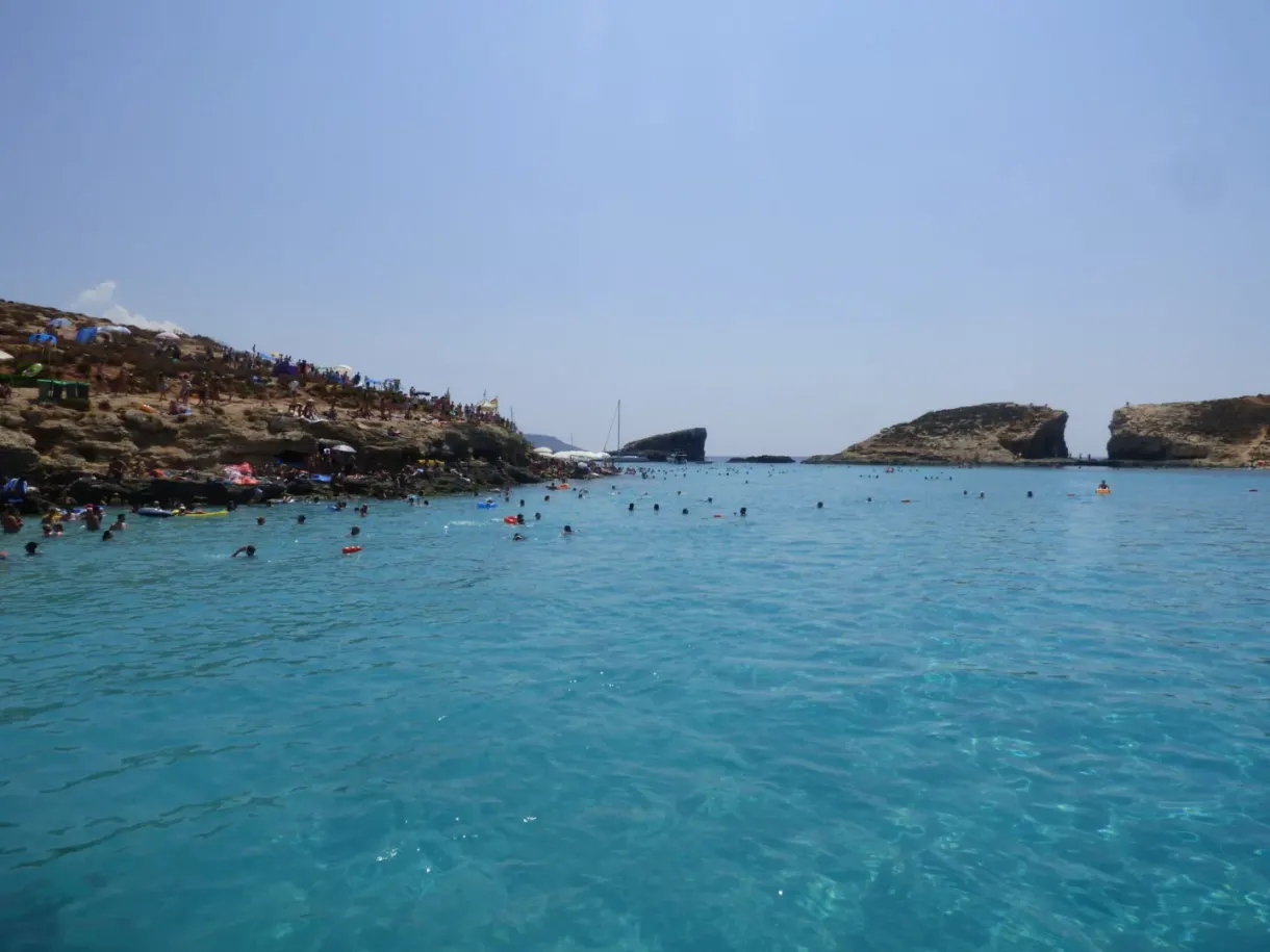 Bathers in the lagoon facing the rocky islet