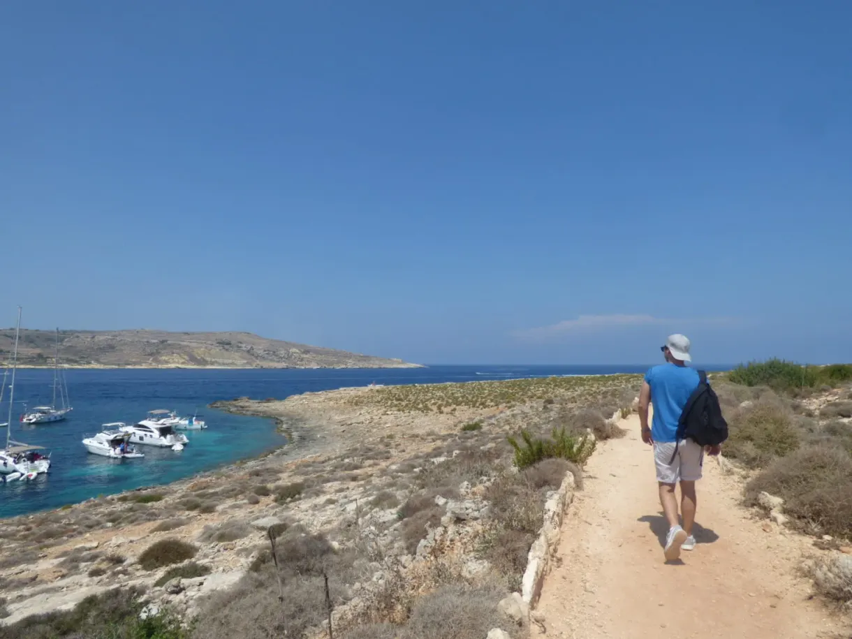 Hiker walking down the path towards the bay