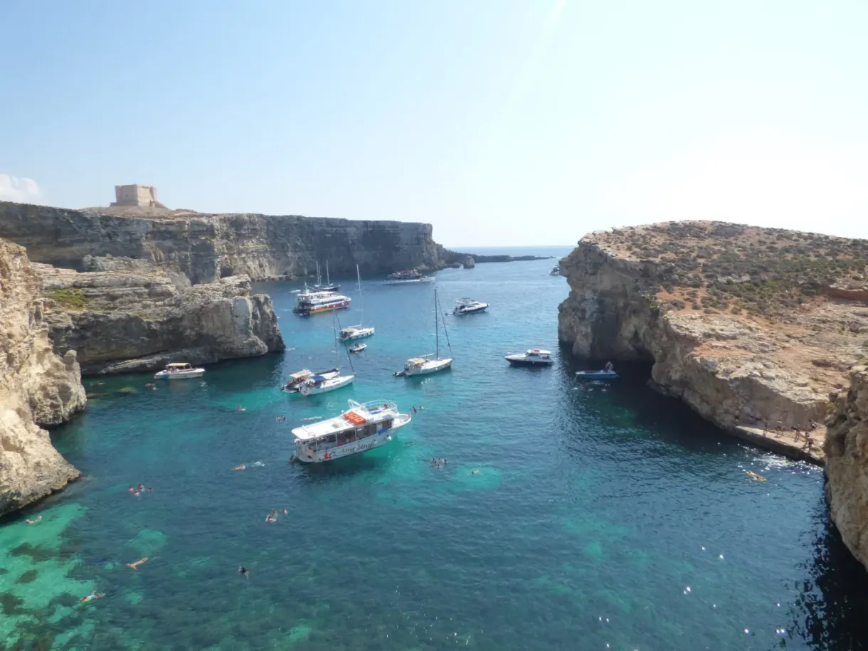 Boats moored between the cliff and the lagoon
