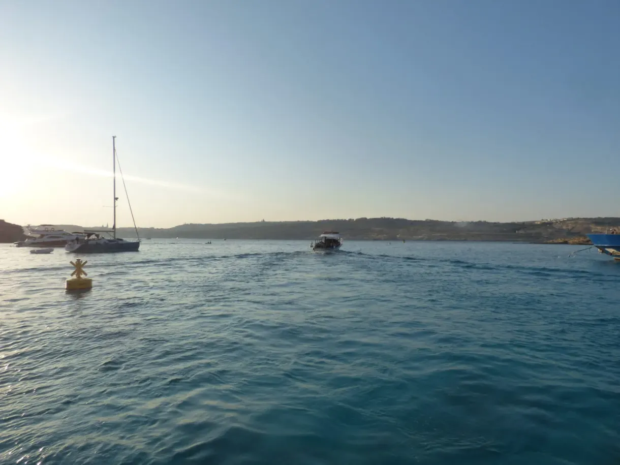 Sailing boat and yellow buoy in the evening light