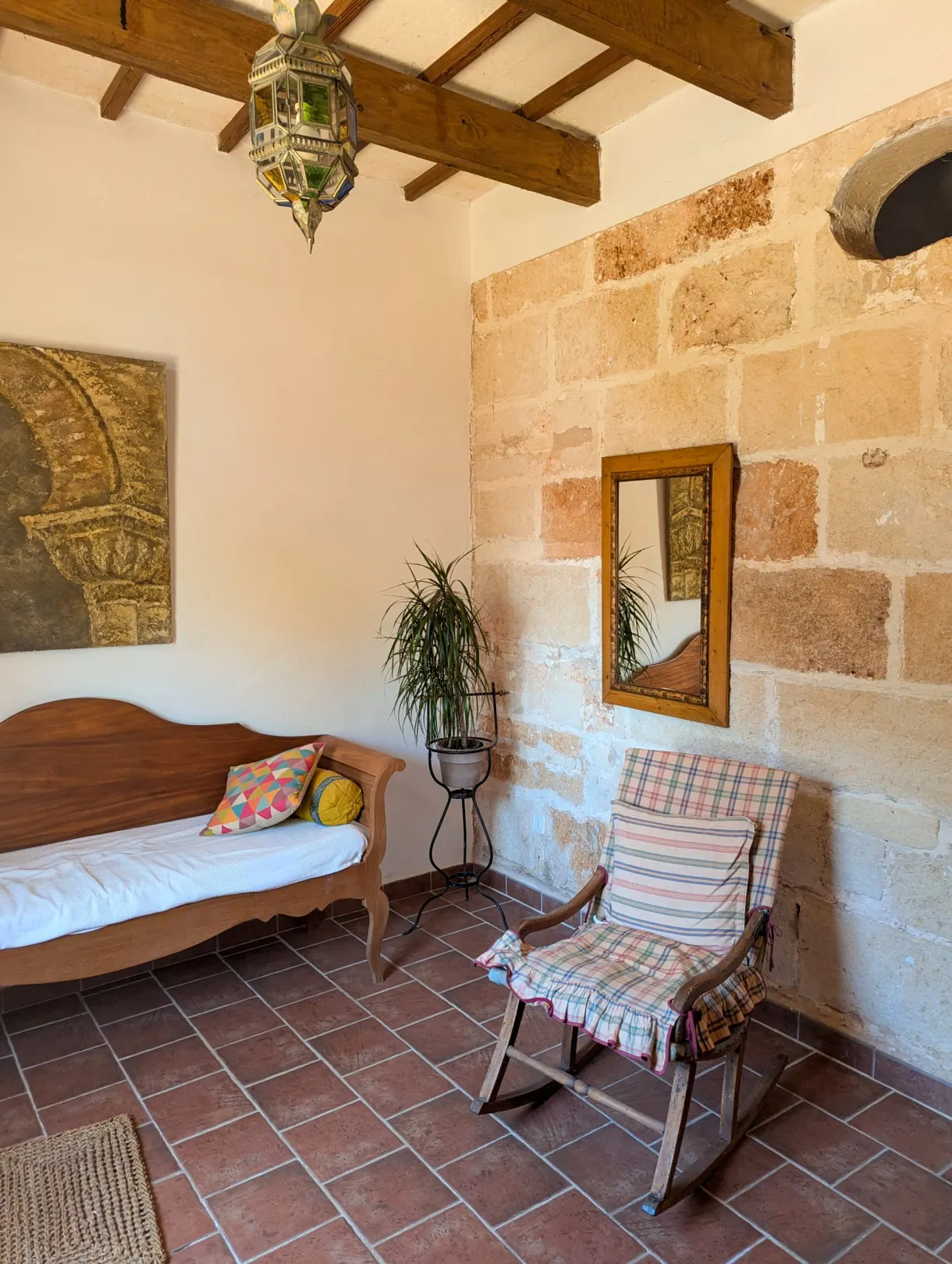 Living room with stone walls, bench seat and rocking chair