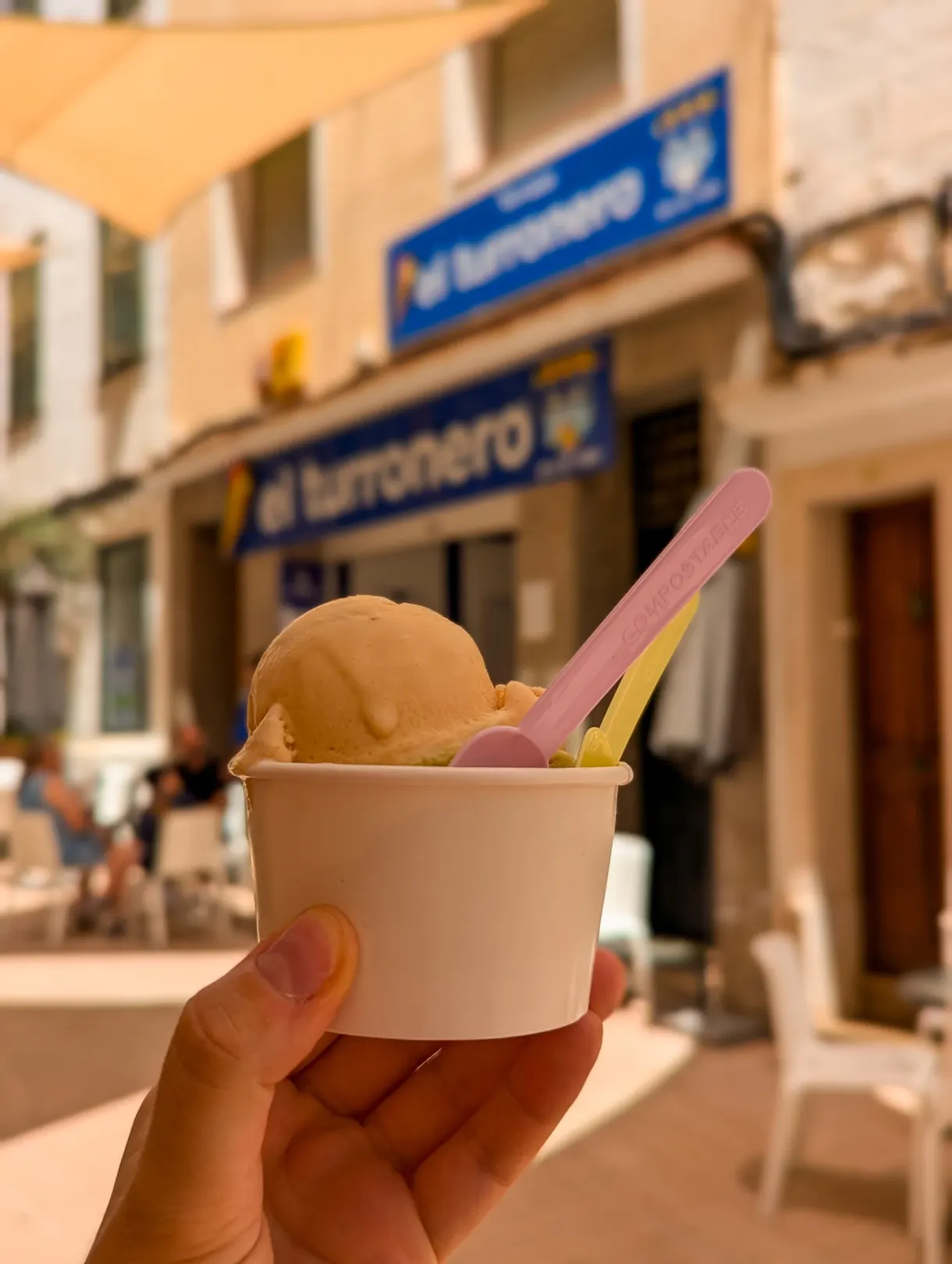 Orange scoop of ice cream held beneath a blue sign