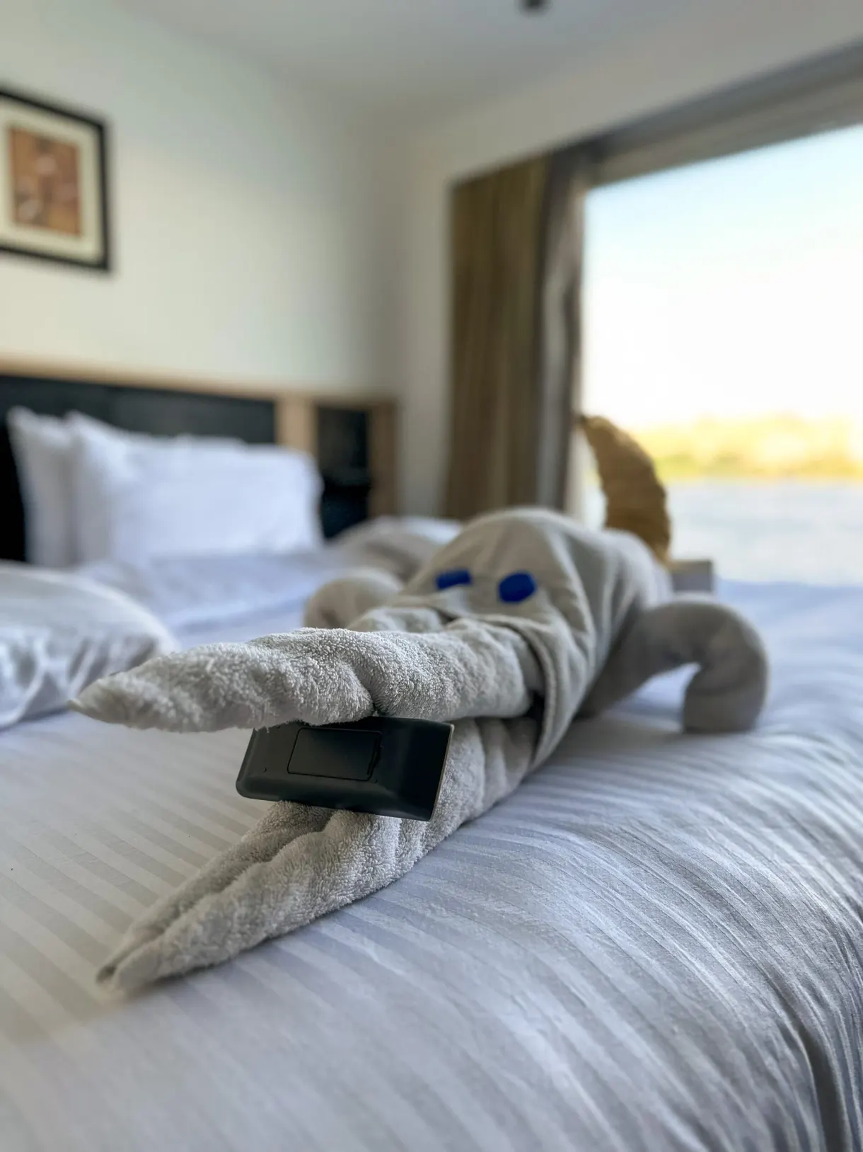 Serviette pliée en animal posée sur le lit face au fleuve